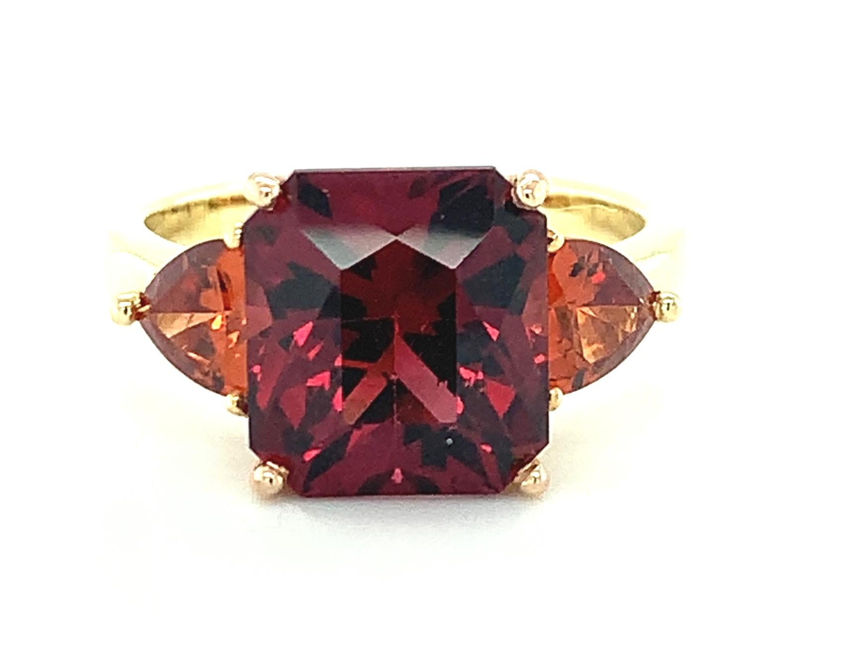 Rich colors and fancy shapes make this colored gemstone ring extra special! We have paired a large, 6.09 carat red garnet with 2 rounded trilliant-cut, orange spessartite garnets in a sleek and modern interpretation of the classic 3-stone ring.
