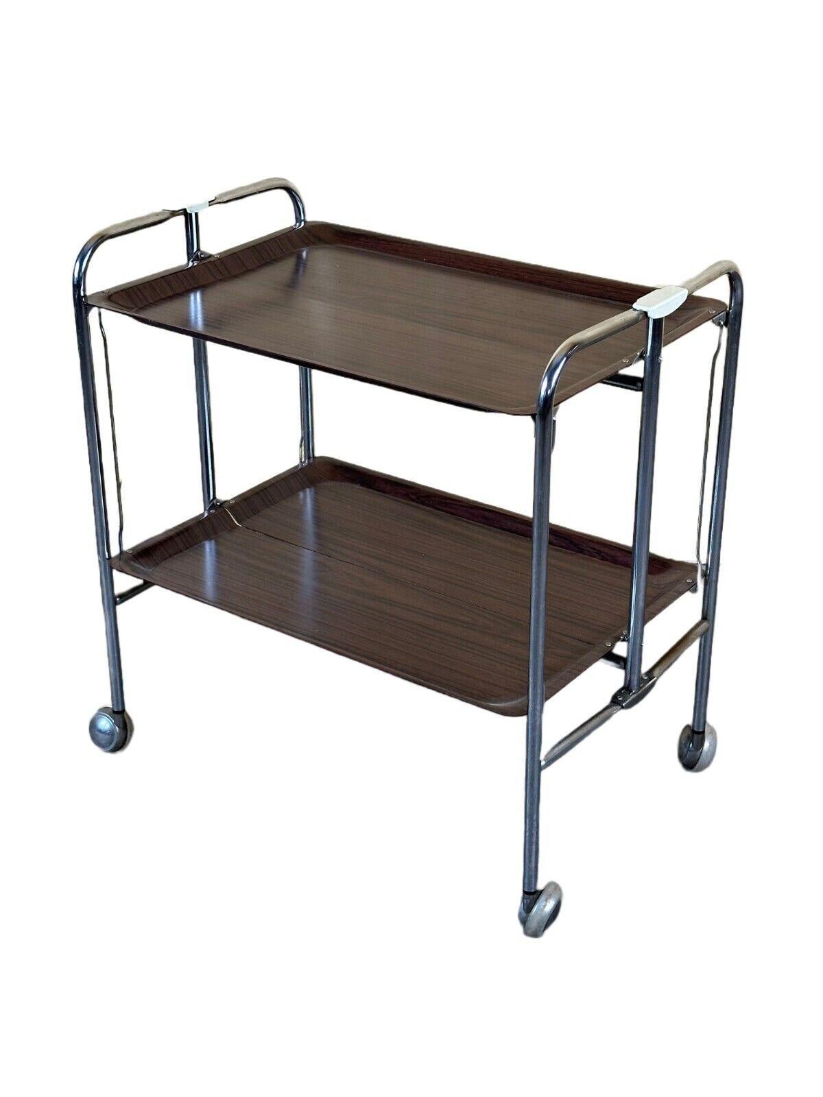 60s 70s serving trolley dinette side table space age brown design

Object: serving trolley

Manufacturer:

Condition: good - vintage

Age: around 1960-1970

Dimensions:

Width = 66cm
Depth = 41.5cm
Height = 68.5cm

Material: metal, plastic

Other