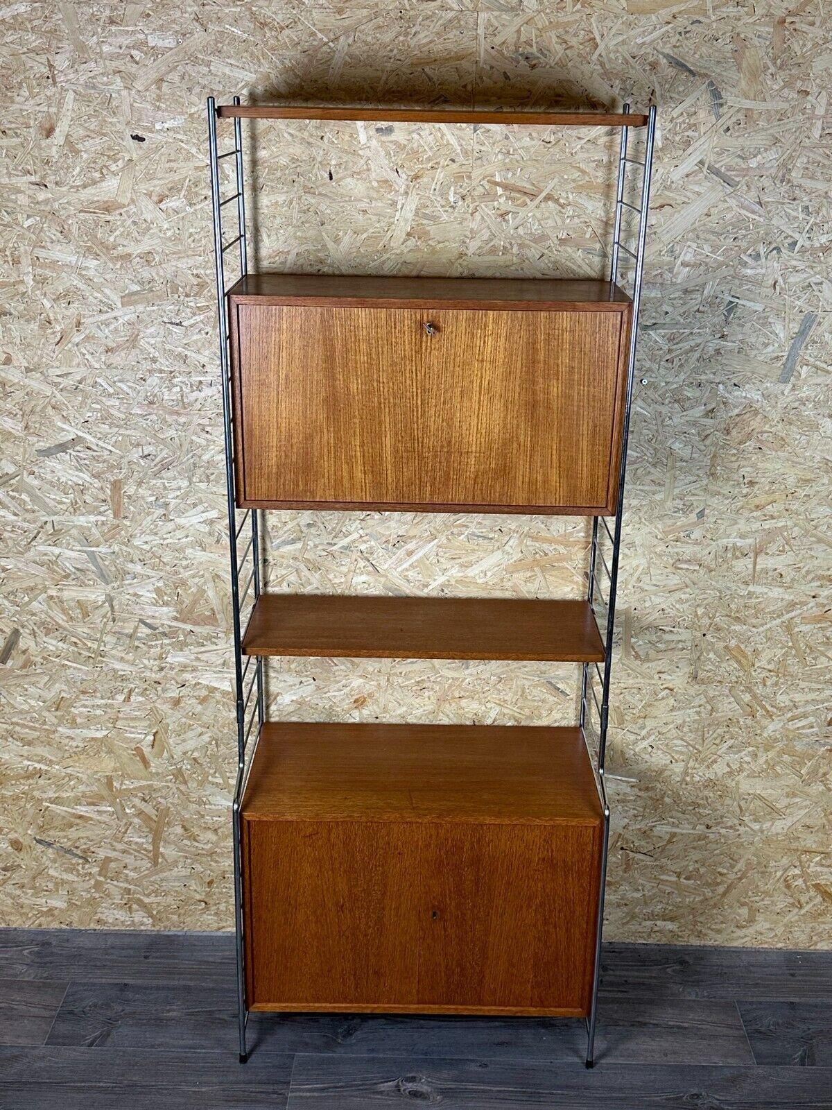 60s 70s teak shelf wall shelf WHB Germany string shelf Danish design 

Object: wall shelf

Manufacturer: WHB

Condition: good - vintage

Age: around 1960-1970

Dimensions:

Width = 73cm
Depth = 36cm
Height = 190cm

Other notes:

The pictures serve