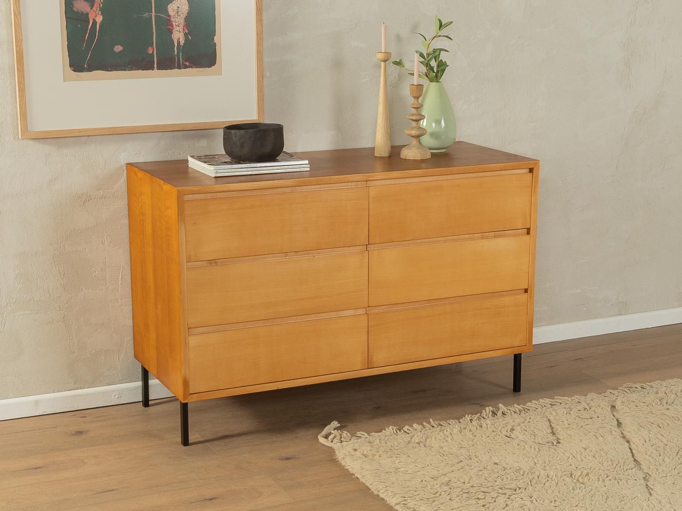 Lovely chest of drawers from the 1960s. High-quality corpus in cherry veneer with six drawers and original square steel feet in black. 

Quality Features:
very good workmanship
high-quality materials
solid wood drawers
Made in Germany. Manufacturer: