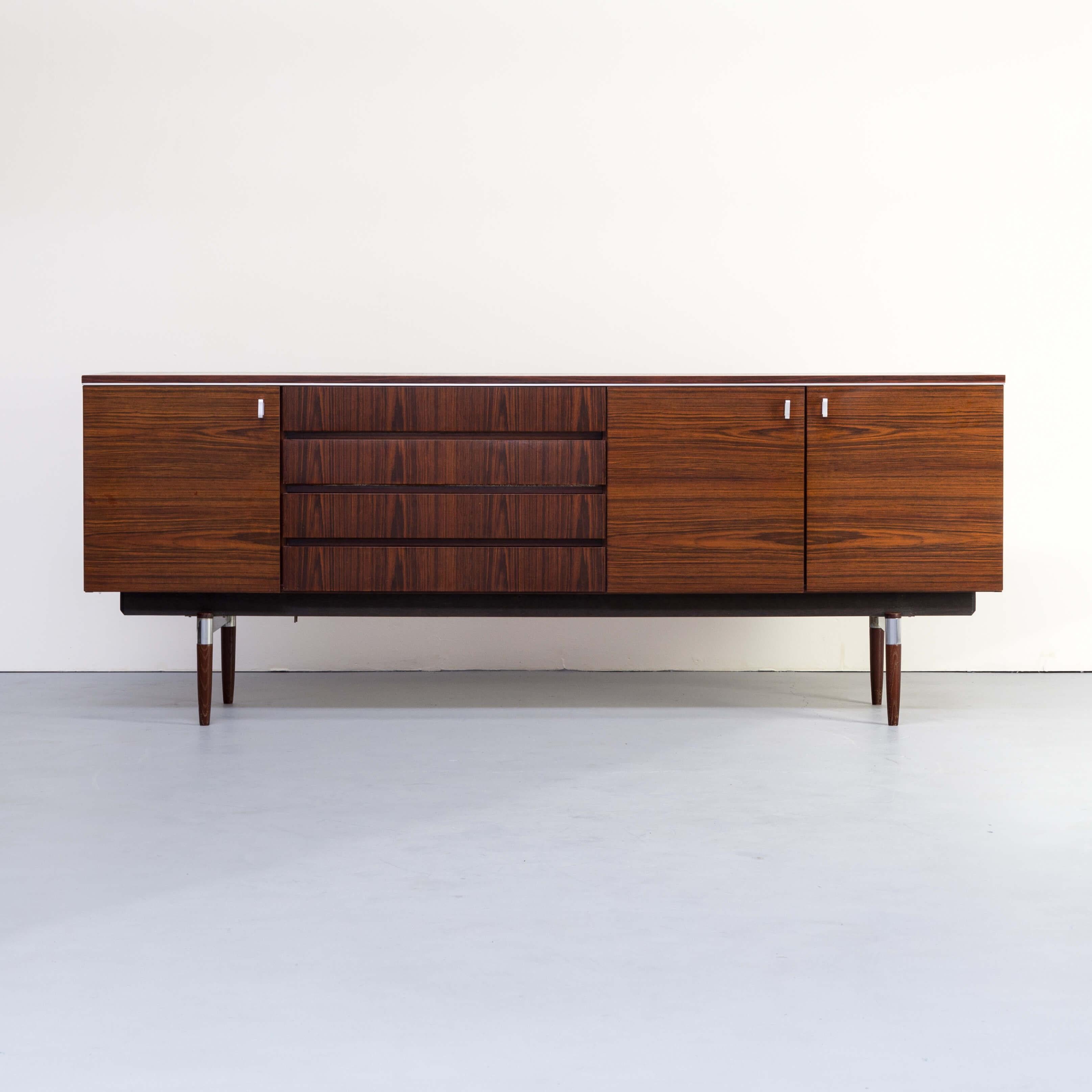 1960s Dutch modernist design rosewood veneer sideboard. Modernist 213cm wide sideboard, in wood veneer. In the innerside of the sideboard there is a working lamp mounted as an extra. The sideboard is beautifull carried on a wood and aluminium foot.