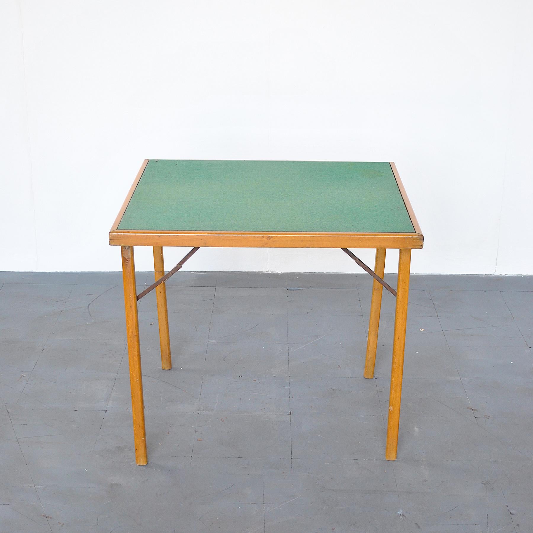 Gros plan sur une table de jeu en bois avec un tissu vert sur le sol.