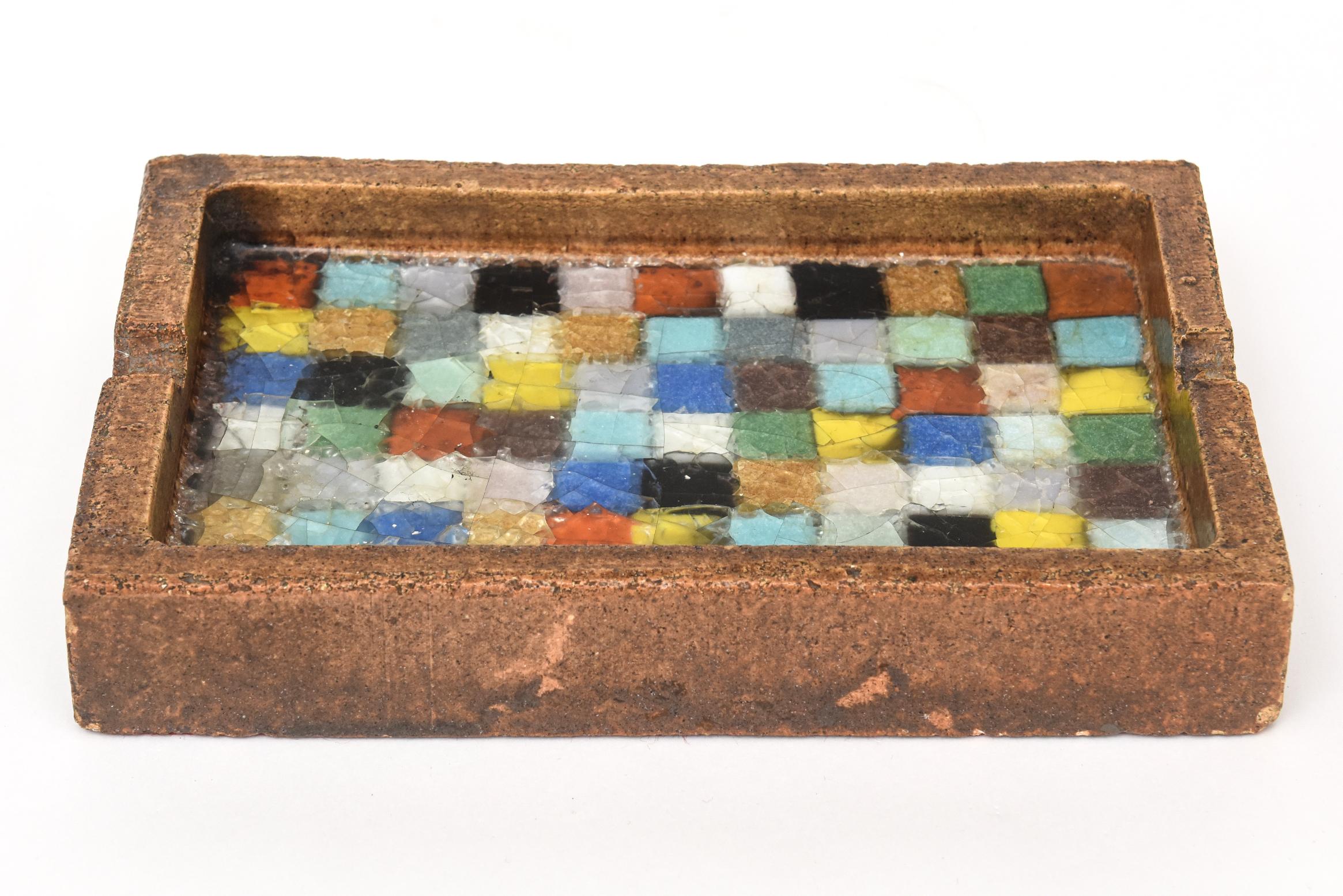 Ce grand cendrier italien des années 1960 en céramique texturée, attribué à Aldo Londi par Bitossi, éblouit par le nombre de couleurs de verre fondu obtenues dans son intérieur en mosaïque de carreaux 