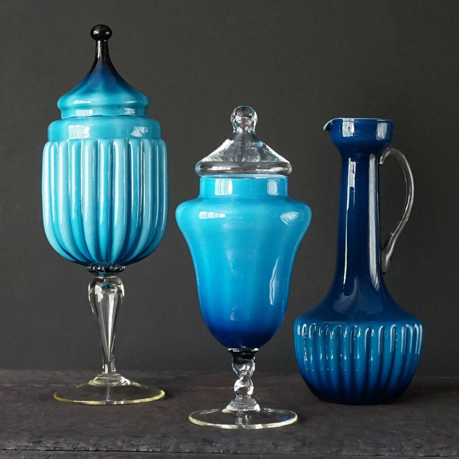 Very pretty set of three 1960s Italian Empoli Rossini and Stelvio Opalina Fiorentina cased glass vases. A high pitcher, vase or decanter and two candy or apothecary jars. 
In deep blue tone matching colours. 
A pretty mixture of different shades of