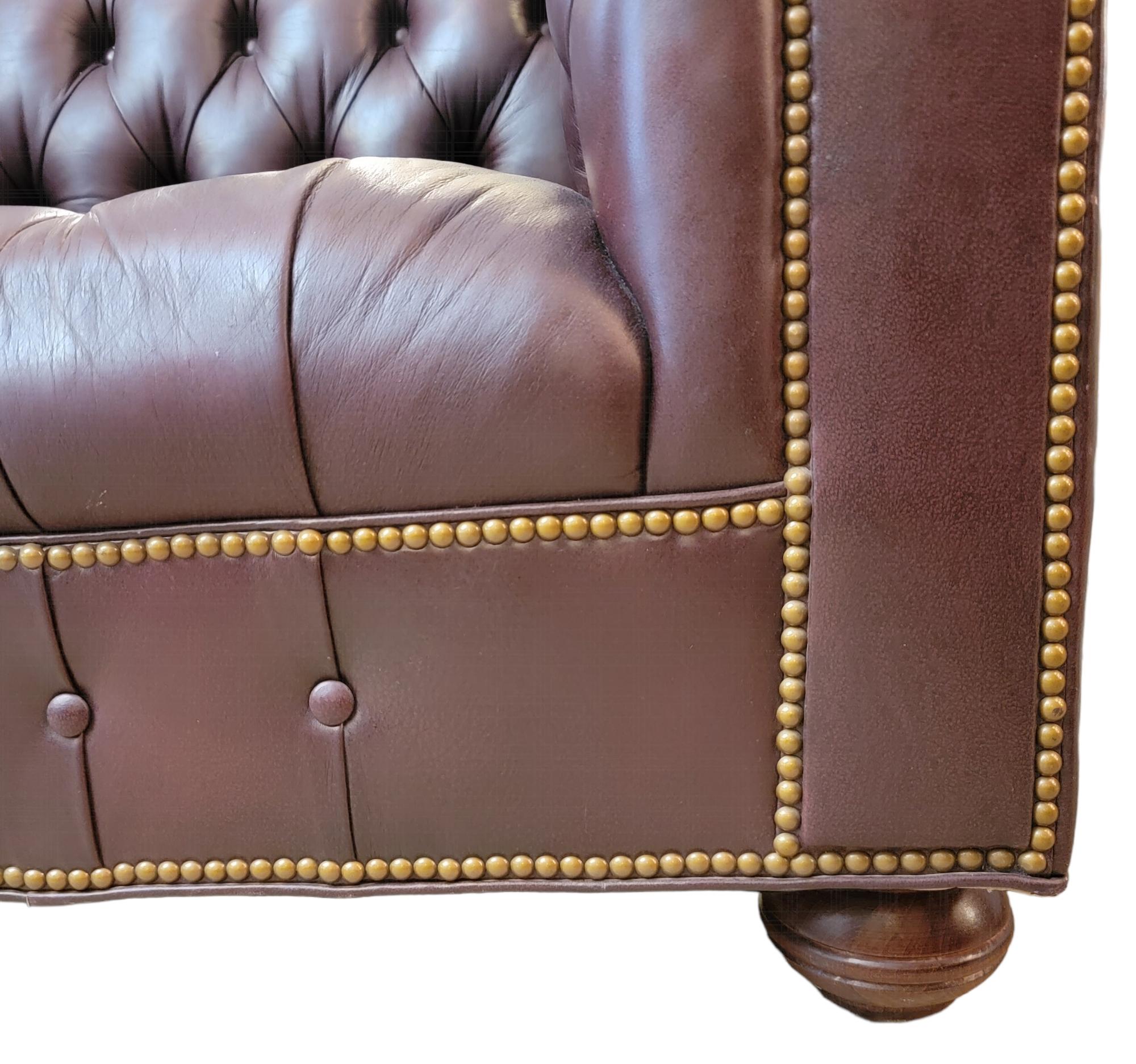 Mid Century 2 Seat chesterfield sofa in a wonderful dark burgundy color with tufted leather and original button knobs, Wonderful Wooden rounded feet.