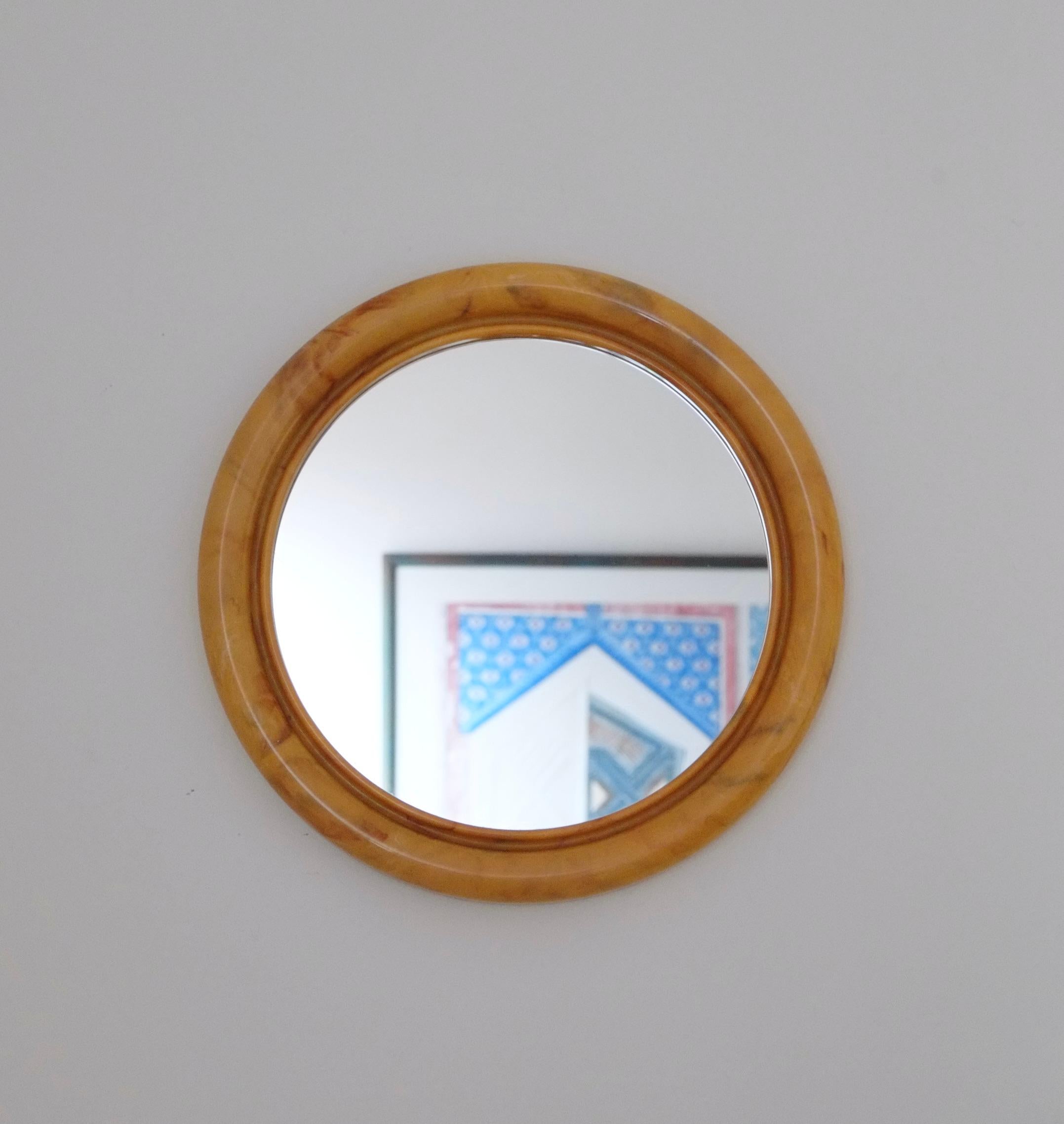 Schöner runder Badezimmerspiegel aus der Mitte des Jahrhunderts. Dieser Vintage-Badezimmerspiegel aus den 60er Jahren hat einen klobigen, geformten Kunststoffrahmen in der schönsten marmorierten Buttertoffee-Farbe. Schwarzes Trägermaterial mit