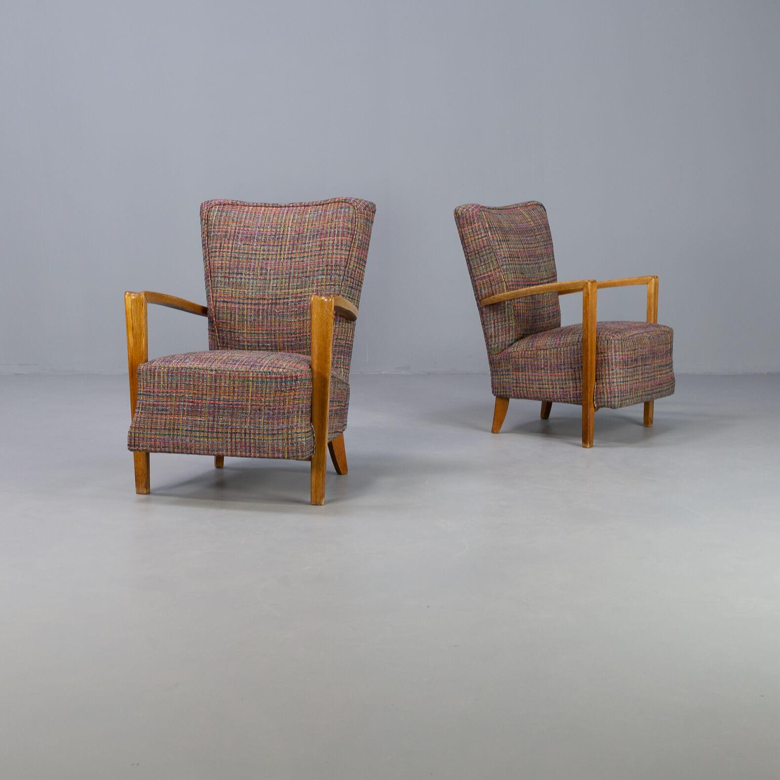 One amazingly beautiful set of two identical armchairs. Frame in oakwood includes beautiful details. The fabric is completely new upholstered Martigny multicolor fabric and the chairs have new singles for the seating. Original 1960s chairs fully new