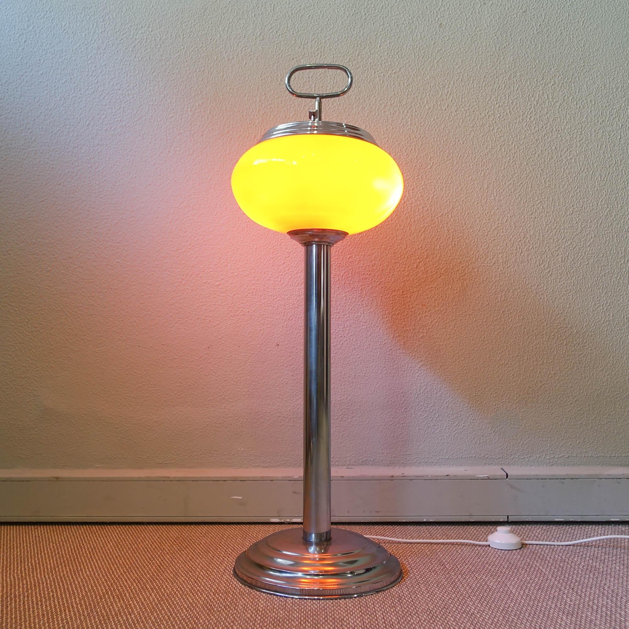This astray/ floor lamp was produced in Portugal and is original from the 1960's.They were specially used on the Casinos in Portugal on that era. It has a chrome metal base, with a chrome stem were an orange opaline glass lampshade is set. On top of
