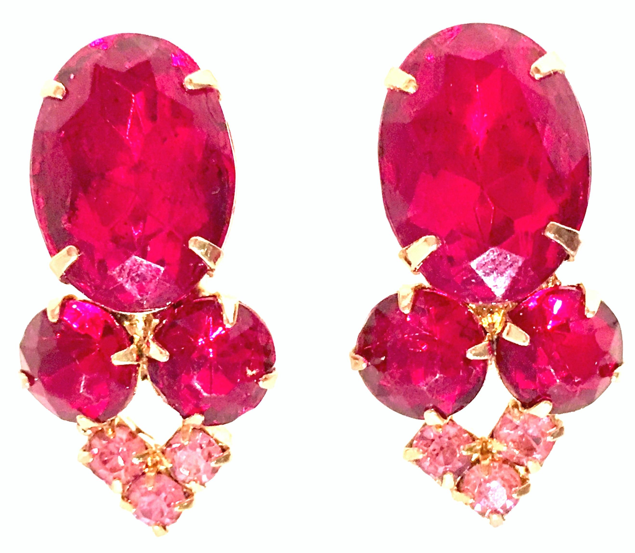 1960'S Gold Plate & Swarovski Crystal Earrings. These clip style earrings feature brilliant cut and faceted prong set ruby and pink sapphire Swarovski crystal stones, with a large oval center stone. Center stone is approximately, 1