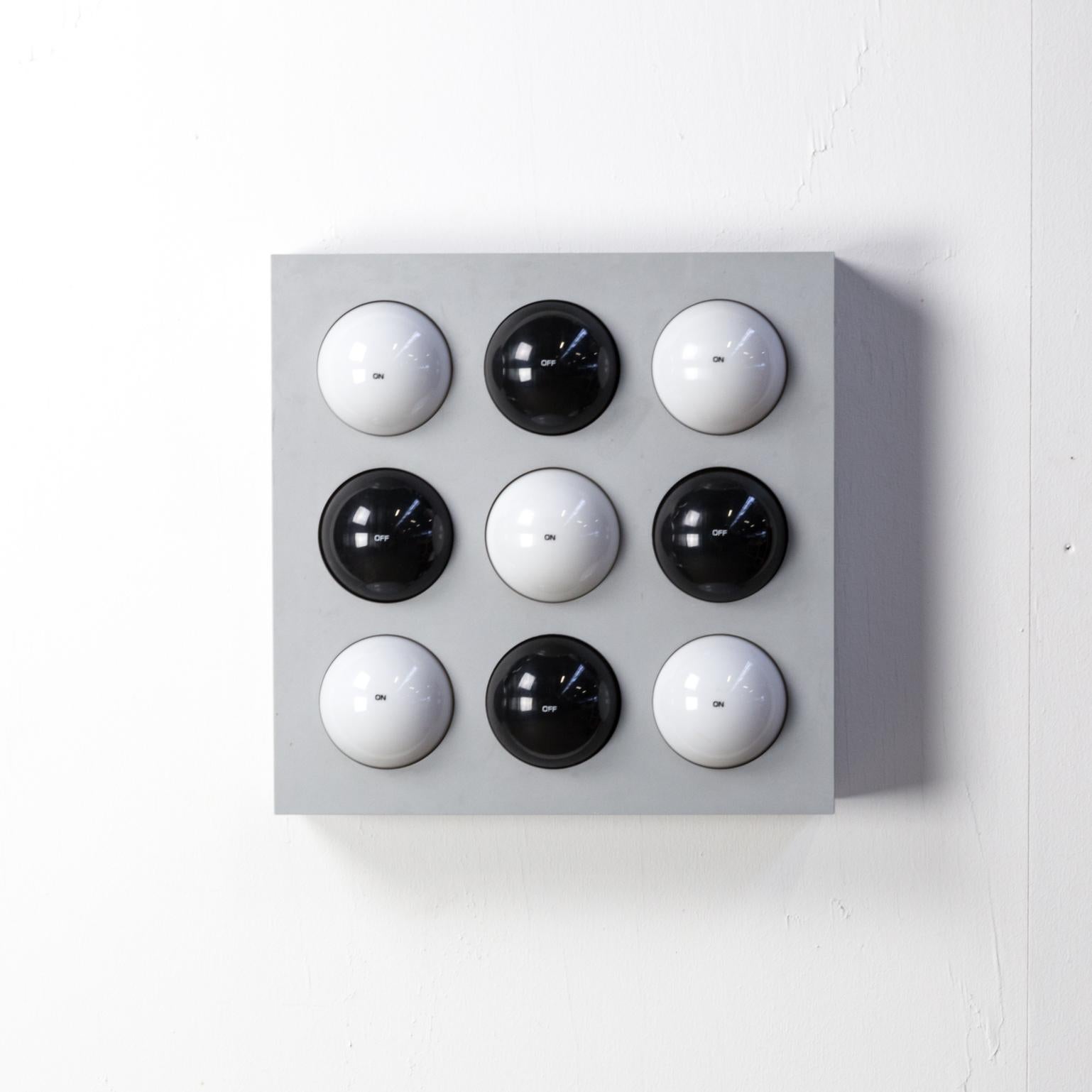 The model “Fifty Fifty” interactive table lamp or wall sconce designed in 1965 by Paul Talman, Switzerland. Reminiscent of his artwork, this lamp has nine two-sided, two-color, rotating plastic balls with 'On' printed to the white side and 'Off'