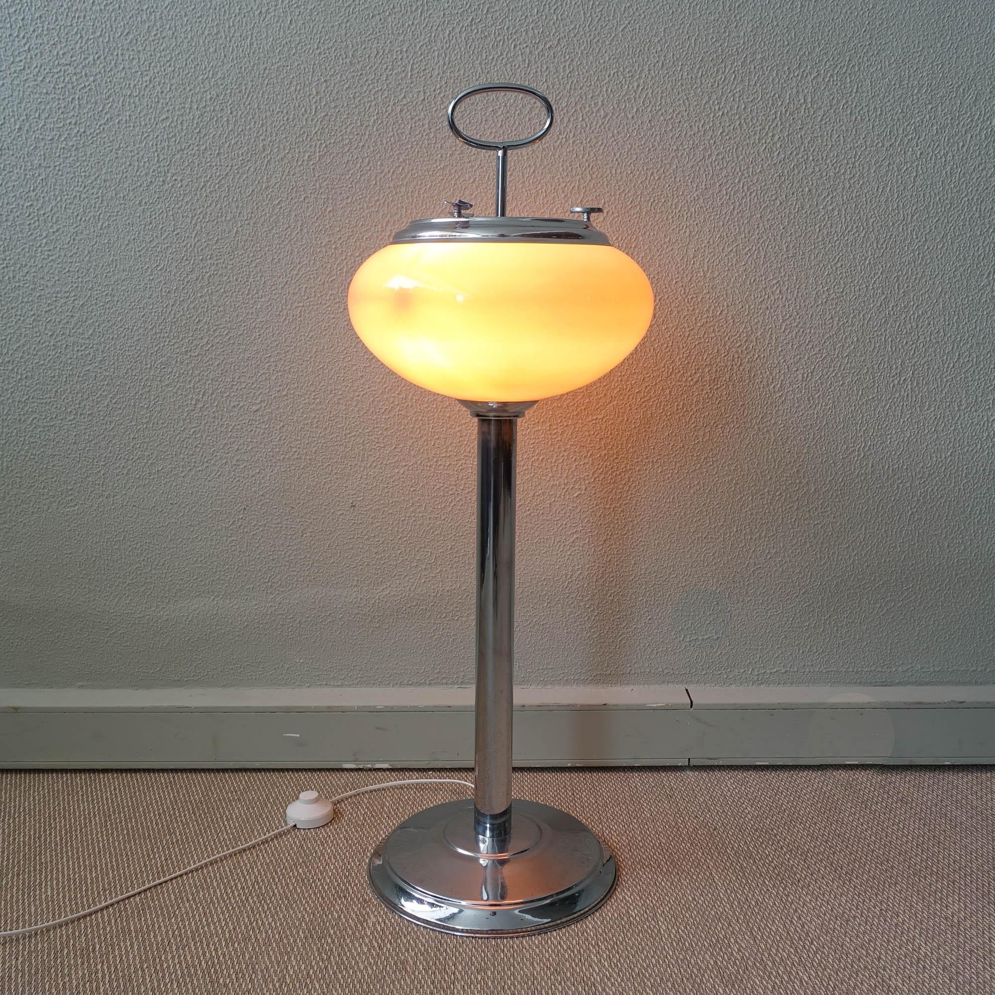 This astray/ floor lamp was produced in Portugal and is original from the 1960's. It  has a chrome metal base, with a chrome stem were a pink opaline glass lampshade is set. On top of this glass is an ashtray, that can be removed when is full,