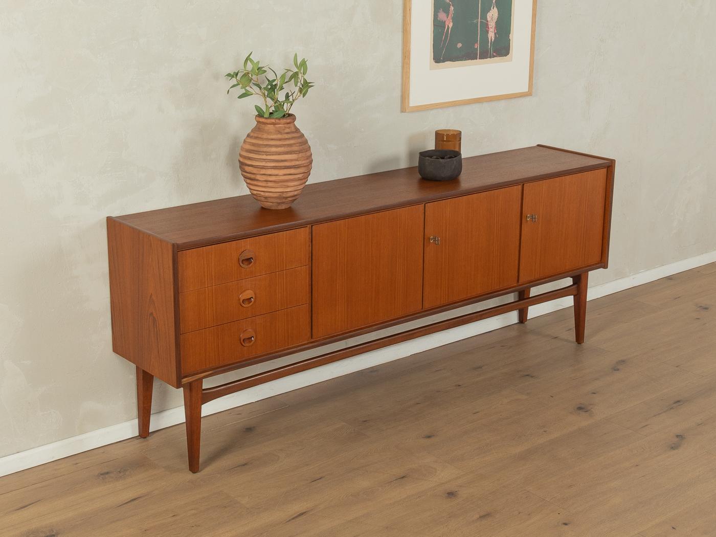 Classic sideboard from the 1960s. High-quality corpus in teak veneer with three drawers, three doors, two shelves and tapered feet.

Quality Features:
very good workmanship
high-quality materials
solid wood drawers
Made in Germany, manufacturer: