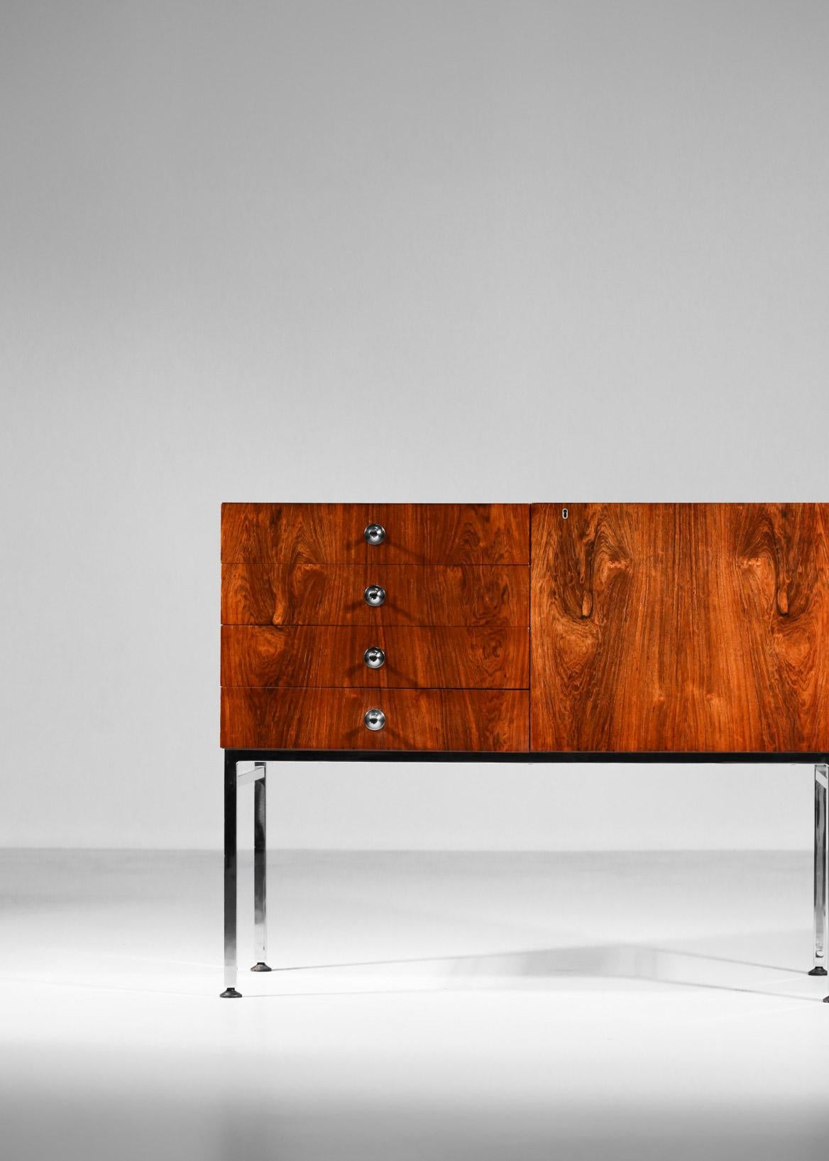 Aparador diseñado en 1958 por el diseñador francés Alain Richard para Meuble TV. 
Excelente elaboración en madera de palisandro que descansa sobre un armazón de acero cromado. 
Compuesto por una columna de cuatro cajones y una puerta abatible, los