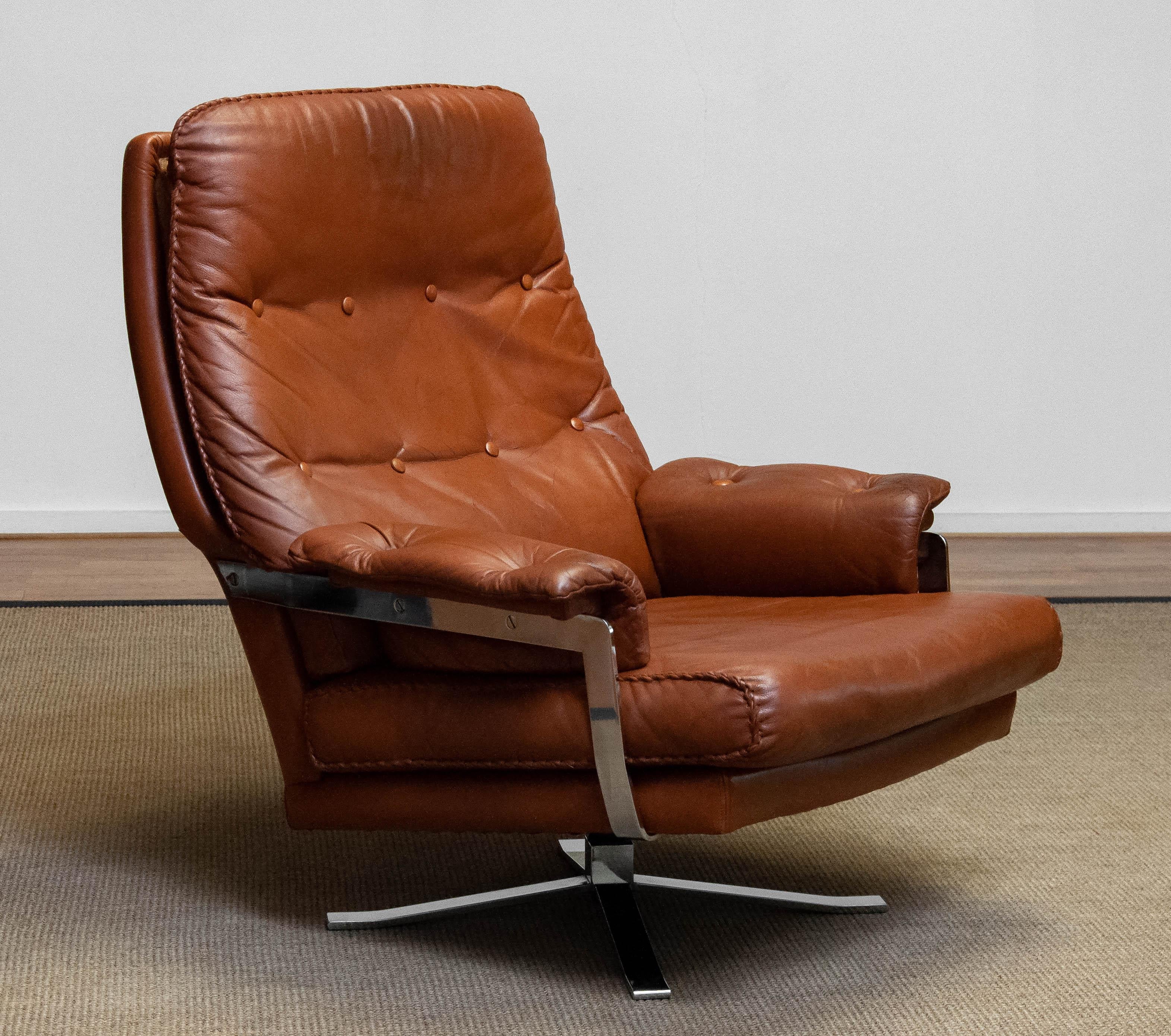 Very comfortable and luxury swivel chair in tan brown hand stitched leather designed by the famous Swedish designer Arne Norell for Vatne Møbler in Norway.
The beautiful tan brown leather is in allover good condition ( one drier spot in the lower
