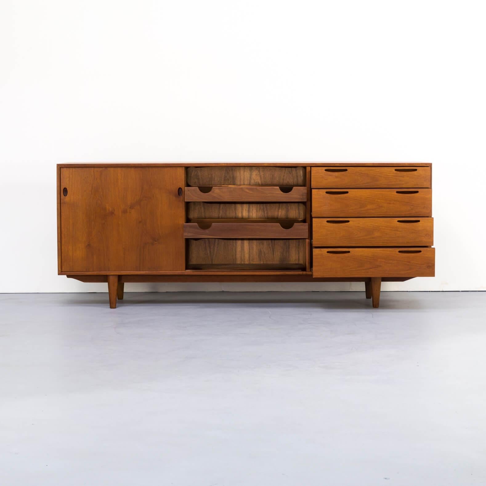 1960s teak sideboard by Ib Kofod-Larsen. This beautiful piece of furniture has an impressive teak wood corpus, that is framed with darker teak on the corpus’ edges. All handles are elegantly worked out and give this sideboard its distinguished look.