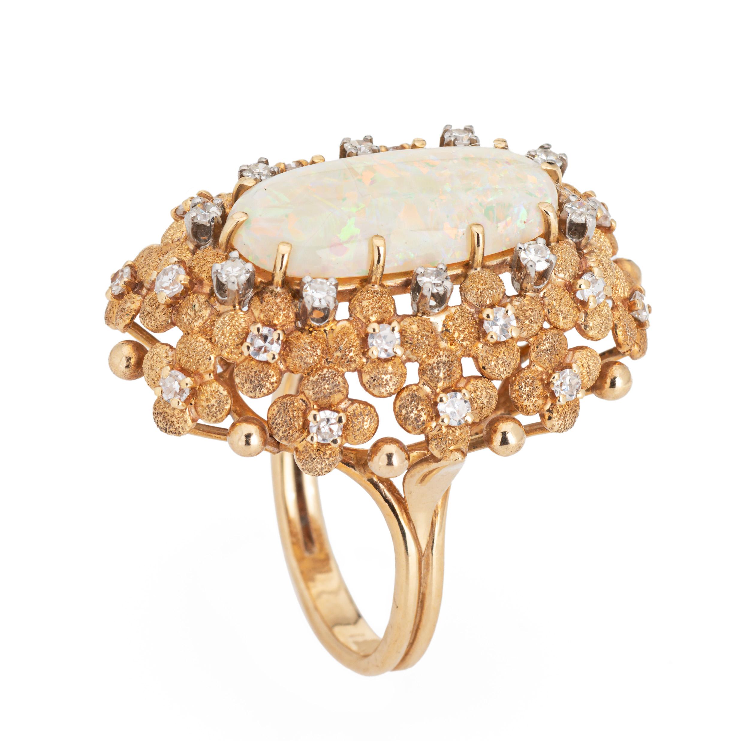 Stylish and finely detailed large opal & diamond cocktail ring crafted in 14 karat yellow gold (circa 1960s).

Cabochon cut opal measures 20mm x 9mm. 30 single cut diamonds total an estimated 0.30 carats (estimated at H-I color and VS2-SI2 clarity).