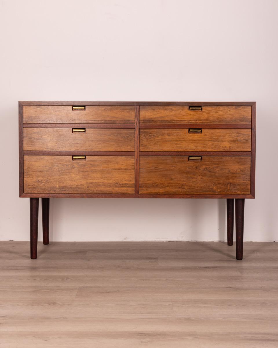Chest of drawers in Rosewood wood, has six drawers with golden brass knobs, Danish design, 1960s.

Conditions: In good condition, it may show signs of wear given by time.

Dimensions: Height 75 cm; Width 110 cm; Length 48 cm

Materials: Wood