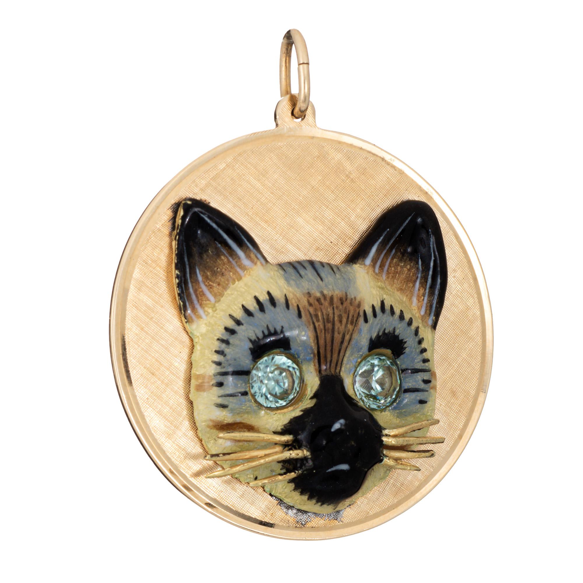 Finely detailed vintage Siamese Cat medallion crafted in 14k yellow gold (circa 1960s).  

The large medallion pendant measures 38mm diameter (1.49 inches). The elaborate design highlights a beautiful Siamese cat, enameled in shades of beige, warm