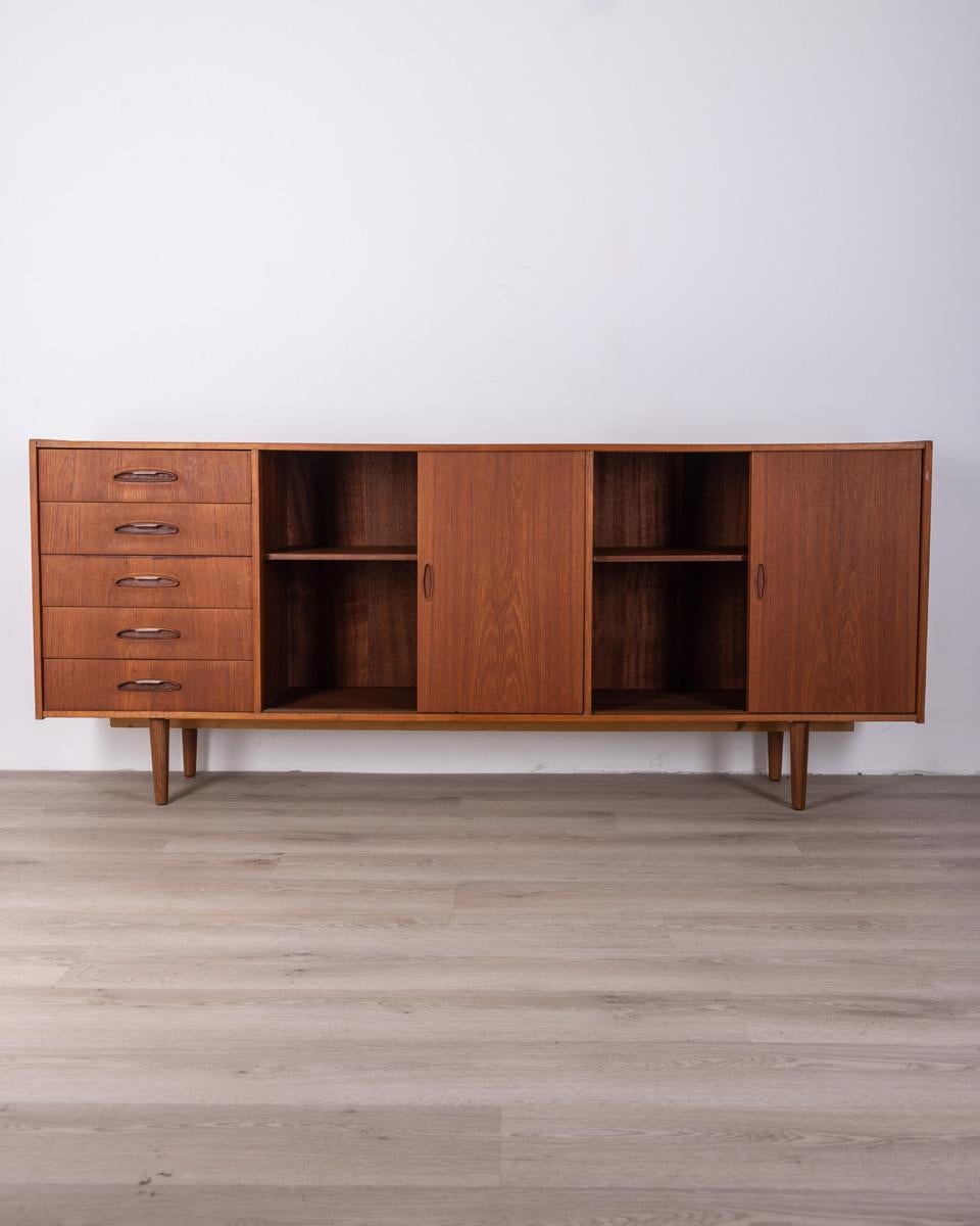 Teak wood sideboard, has five drawers and four sliding doors, Danish design, 1960s.

CONDITIONS: In good condition, it may show signs of wear given by time.

DIMENSIONS: Height 83 cm; Width 200 cm; Length 39 cm

MATERIALS: Wood

YEAR OF