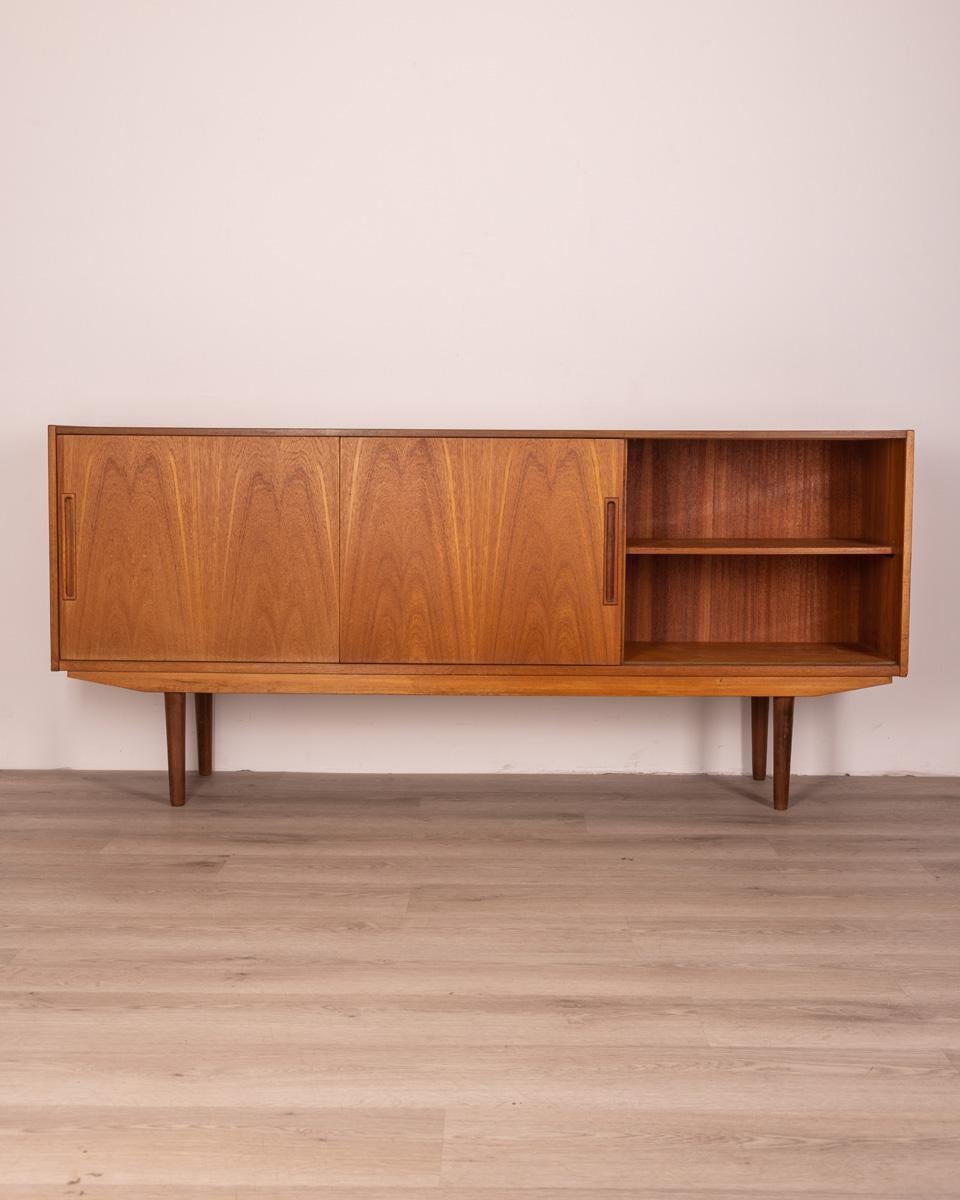 Teak wood sideboard sideboard, has two sliding doors and four drawers in the central part, Danish design, 60s.

Conditions: In good condition, it shows signs of wear given by time.

Dimensions: Height 82 cm; Width 181 cm; Length 39