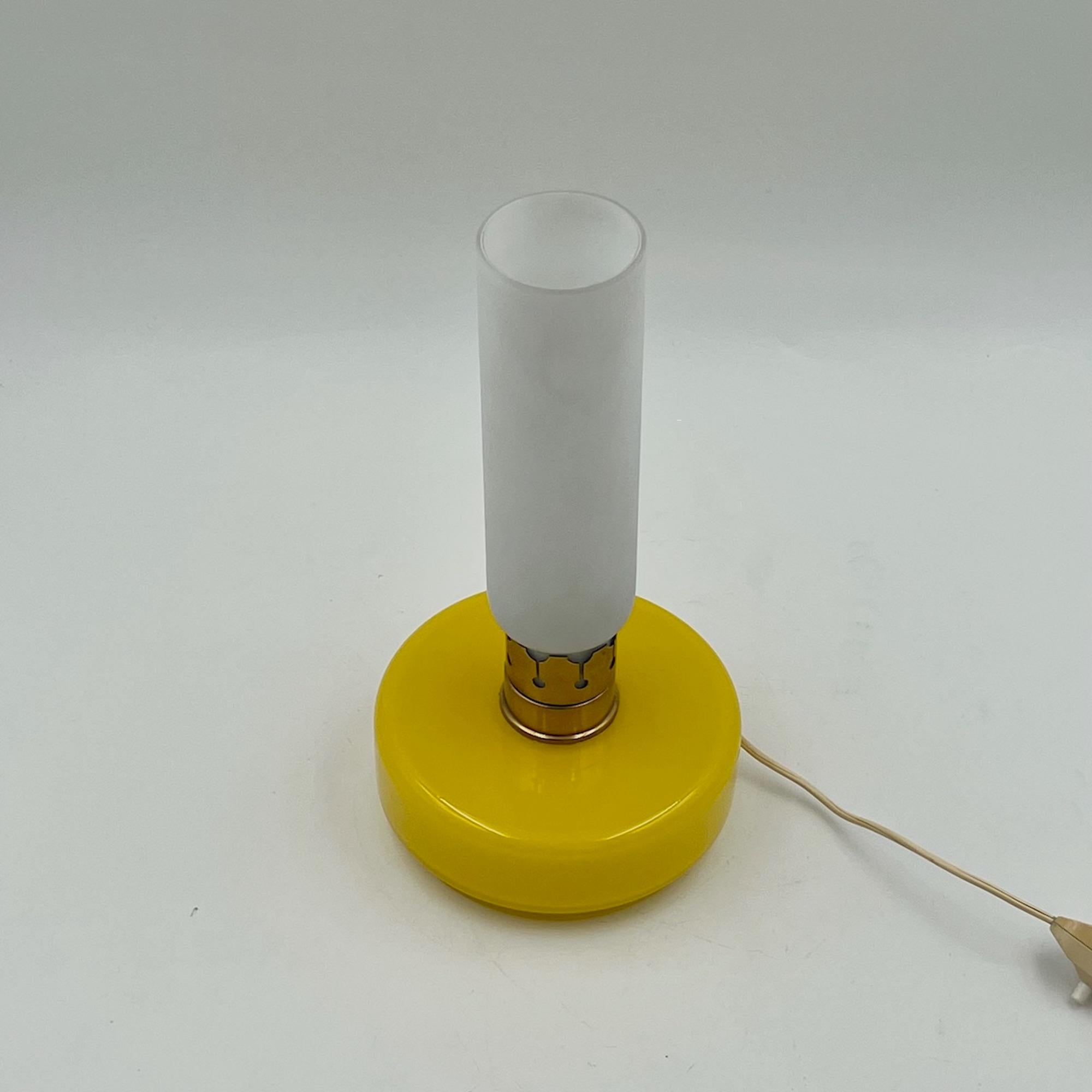 Discover the timeless elegance of this charming vintage yellow glass lamp, a true gem from the 60s. Featuring a brilliant yellow glass base, this table or bedside lamp exudes a warm and inviting glow that instantly elevates any space. The elegant