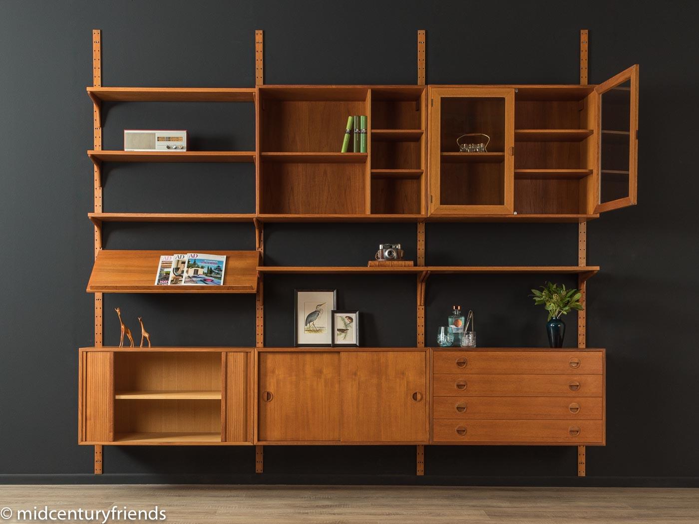 Classic shelving system from the 1960s by HG Furniture. The high-quality containers and shelves are veneered in teak. The system consists of five shelves, two containers with tambour doors, one container with glass doors, one container with drawers,
