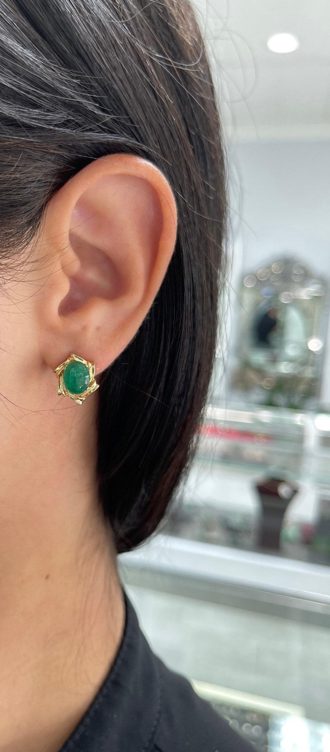 Featured here is a beautiful set of oval-cut cabochon emerald hand-made unique studs in fine 14K yellow gold. Displayed are dark rich-green emeralds with very good transparency, accented by a simple bezel set victorian vintage gold mount, allowing