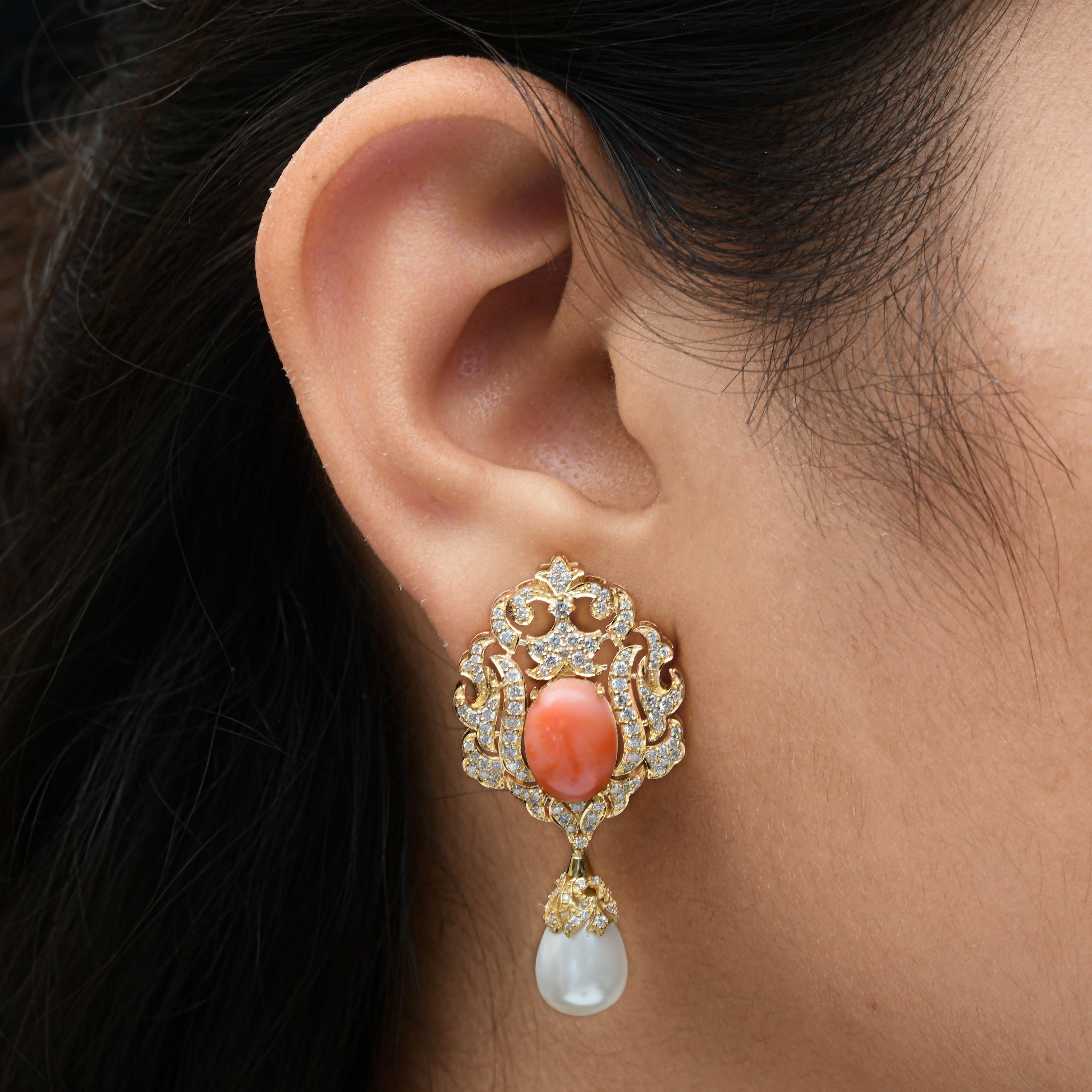 6,1 Karat Koralle 11,84 Karat Perle 1,47 Karat SI/H Diamant 18k Gelbgold Ohrringe 
Der obere Teil ist mit einem ovalen Korallenstein in der Mitte geschmückt. Es ist von einem kunstvollen, filigranen Goldrahmen umgeben. Der goldene Rahmen ist
