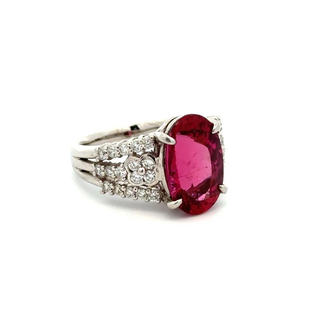 Simply Beautiful! Finely detailed Rubellite Tourmaline and Diamond Platinum Solitaire Cocktail Ring. Centering a securely nestled Hand set Oval Rubellite, weighing approx. 6.11 Carats. Accented on either side by Round Brilliant Cut Diamonds, approx.