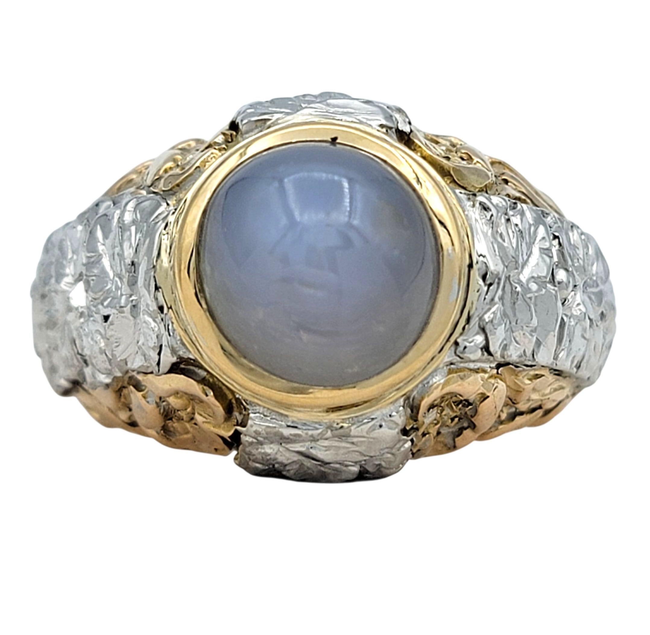 Dieser auffällige Solitärring aus Sternsaphir zeigt einen fesselnden graublauen Sternsaphir im Cabochon-Schliff, der für sein natürliches Phänomen bekannt ist, ein strahlendes sternförmiges Muster auf der Oberfläche zu zeigen. Der Saphir ist in eine