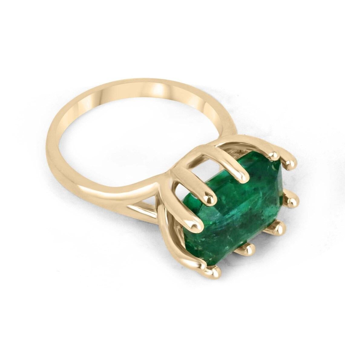 This solitaire ring boasts a breathtaking centerpiece in the form of a 6.12-carat emerald cut emerald. The emerald features a deep, rich green color that is truly stunning and displays outstanding characteristics. The emerald is set horizontally,