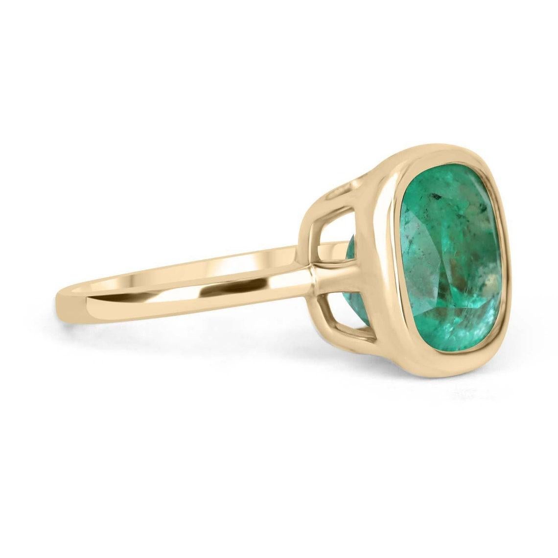 This ring is not for the faint of heart! Displayed is a medium Colombian emerald solitaire cushion-cut engagement/right-hand ring in 14K yellow gold. This gorgeous solitaire ring carries a full 6.12-carat emerald in a golden bezel setting. The
