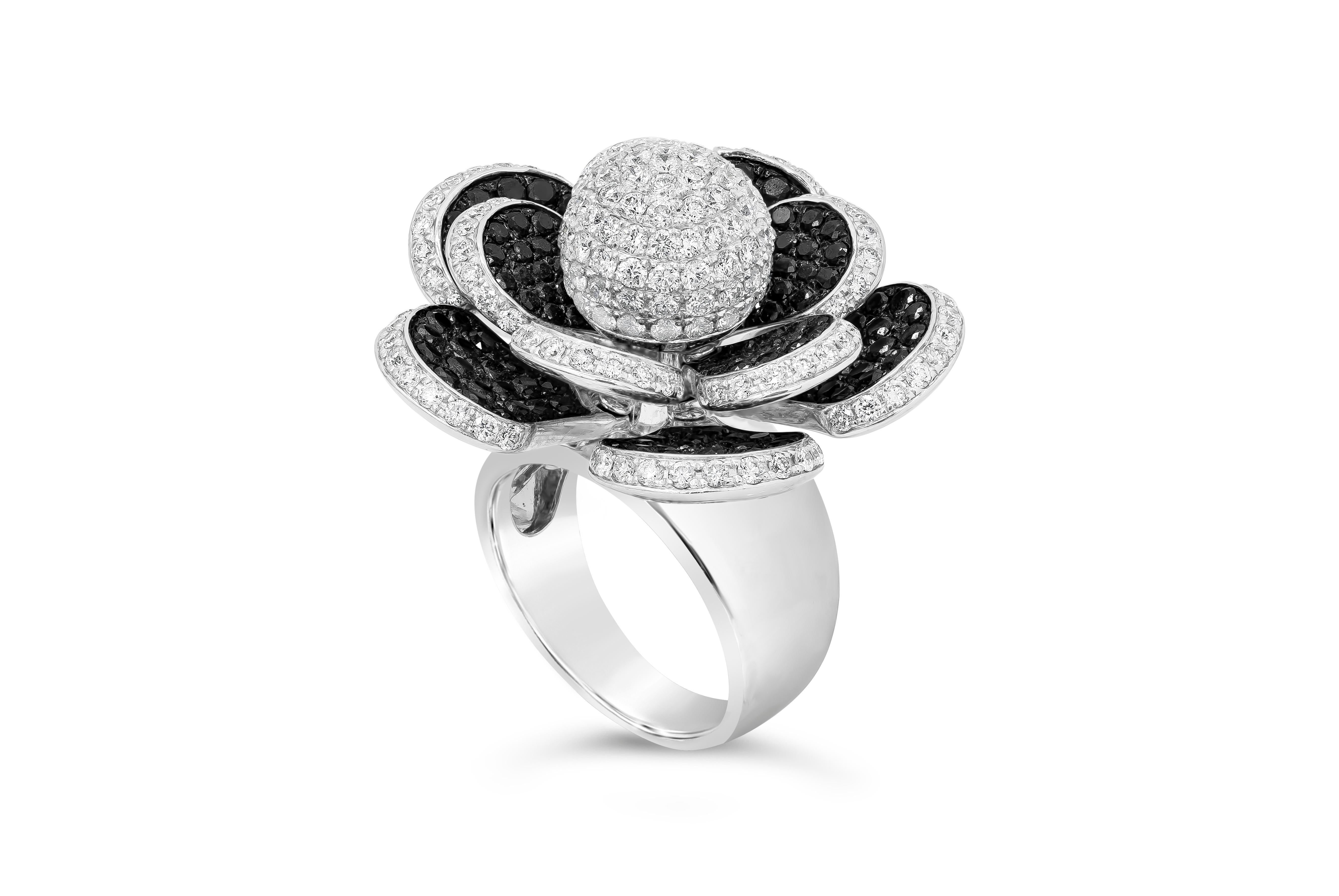 Ein modischer Ring mit einer runden, mit runden Brillanten besetzten Kugel, umgeben von Blütenblättern, die mit schwarzen und weißen Diamanten besetzt sind. Die Blütenblätter sind beweglich und drehen sich um das Zentrum. Schwarze Diamanten haben