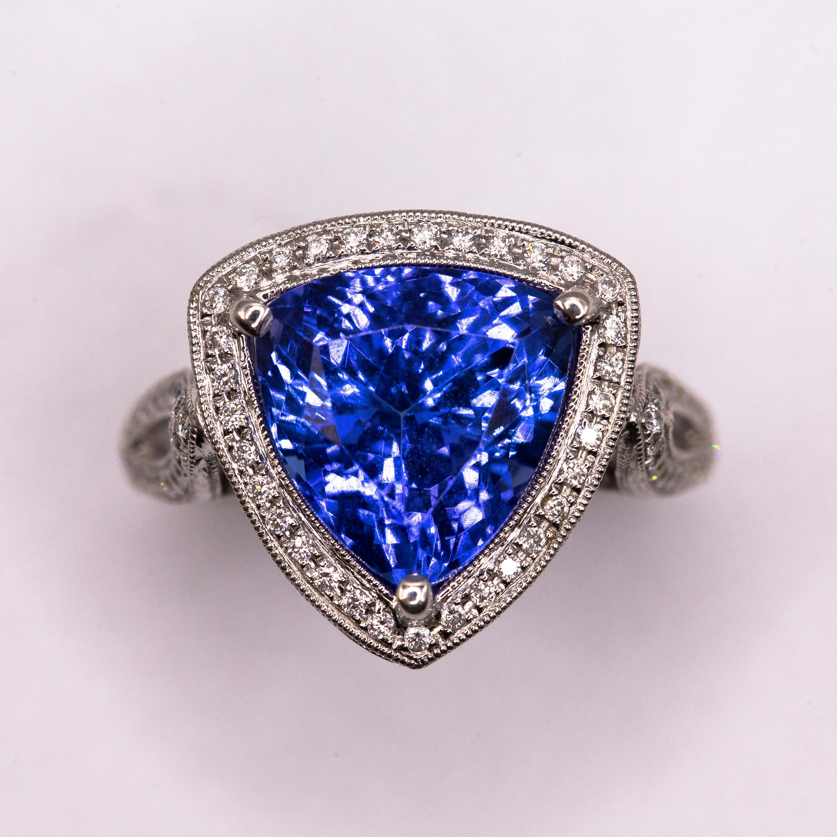 An spectacular, highly transparent and intense near flawless trillion-cut 6.13 carat Tanzanite was inspiration for this one- of- a kind hand crafted ring in 18k white gold. Owing to its expert cut and proportion, the center gem provides perfect