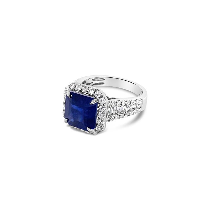 This one of a kind royal blue 6.14 carat octagonal cut natural sapphire is surrounded by 1.36 carat total weight in baguette and round brilliant cut diamonds on the band and halo, set in 18 karat white gold. This is currently a size 7 but can be