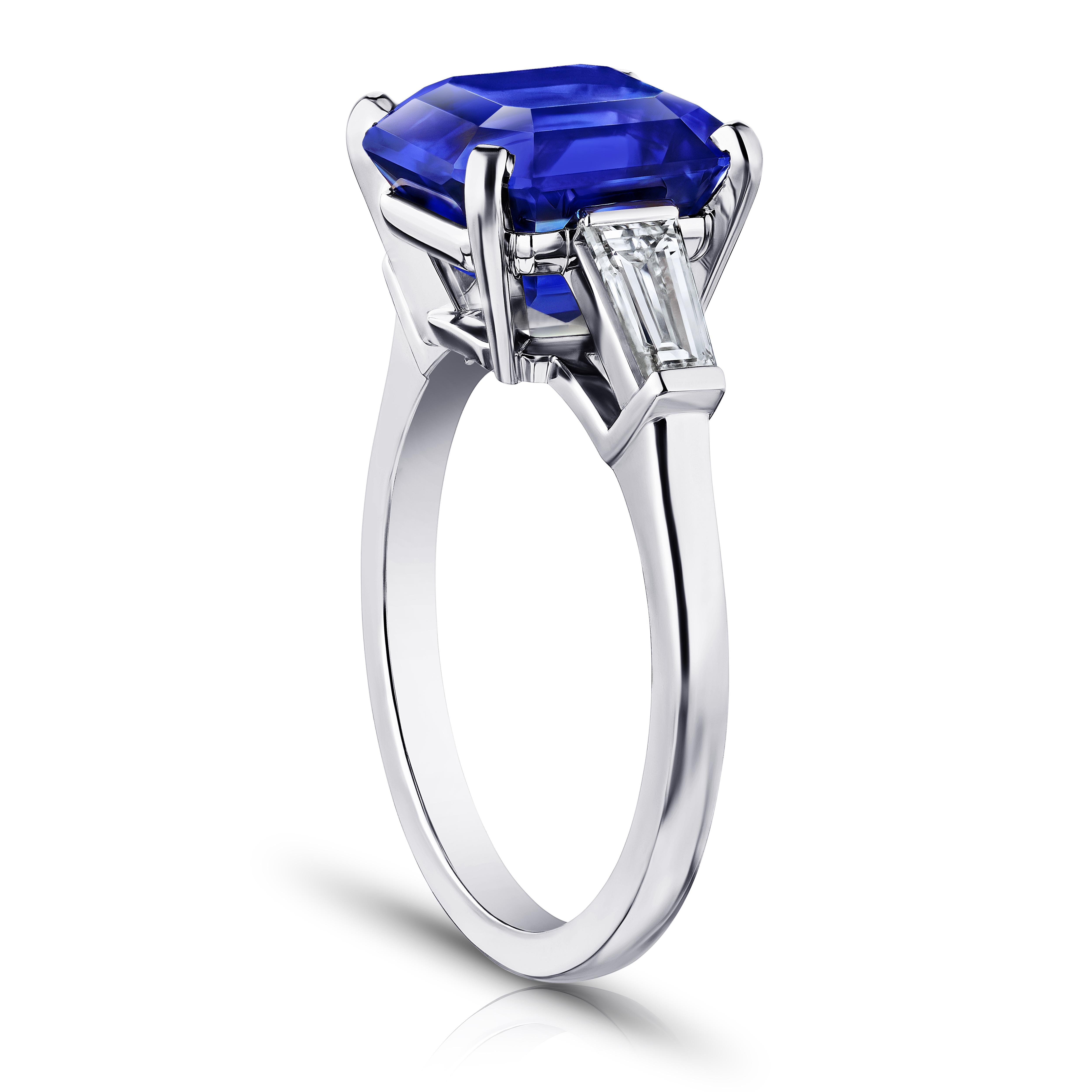 6.16 carat square emerald blue sapphire with tapered baguette diamonds .55 carats set in a platinum ring. Size 7.

