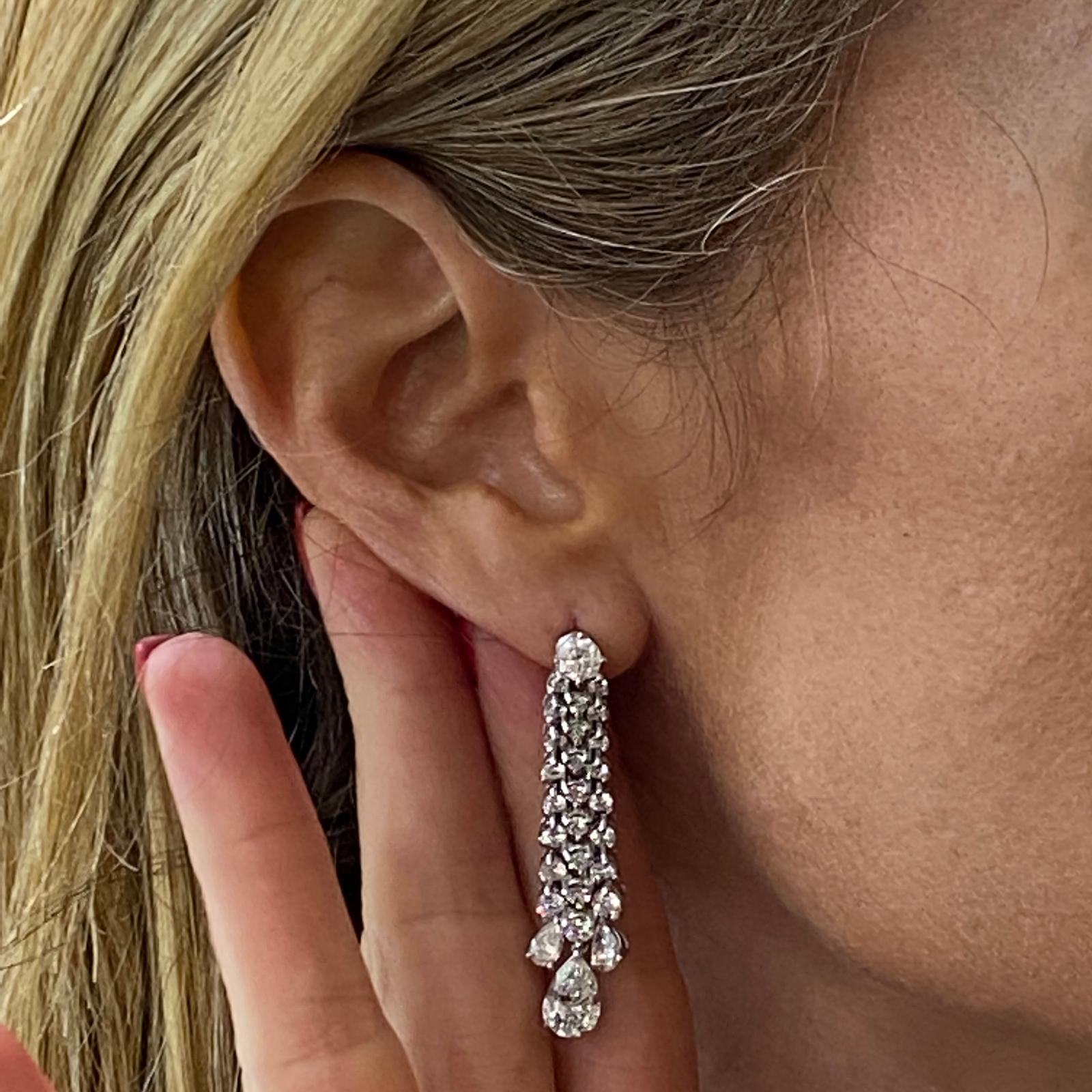 Stunning diamond drop earrings circa 1970's. The earrings feature two pear shape diamond drops that are approximately 2.00 carat total weight. The dangle earrings feature another 4.17 carats of pear and round brilliant cut diamonds. The diamonds are