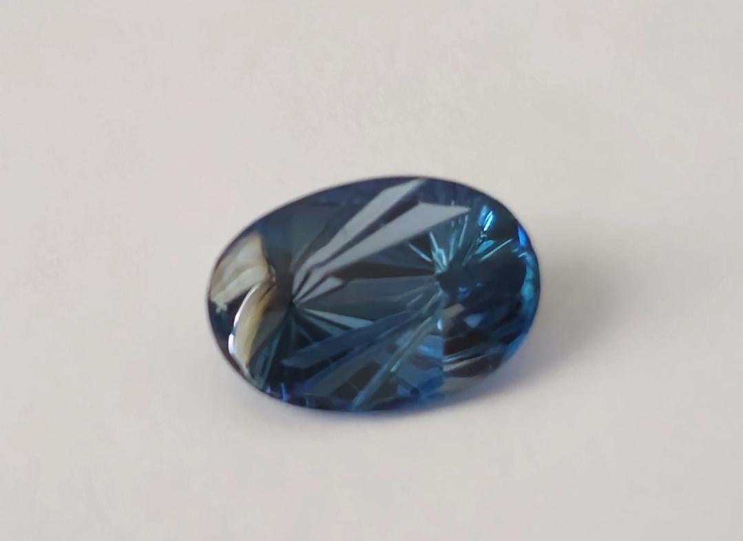 This stunning 6.17 ct oval London Blue Topaz is the perfect addition to any jewelry collection. With its unique fantasy cut, this gemstone is truly one-of-a-kind. The rich blue hue and exceptional clarity make it a sought-after piece for collectors