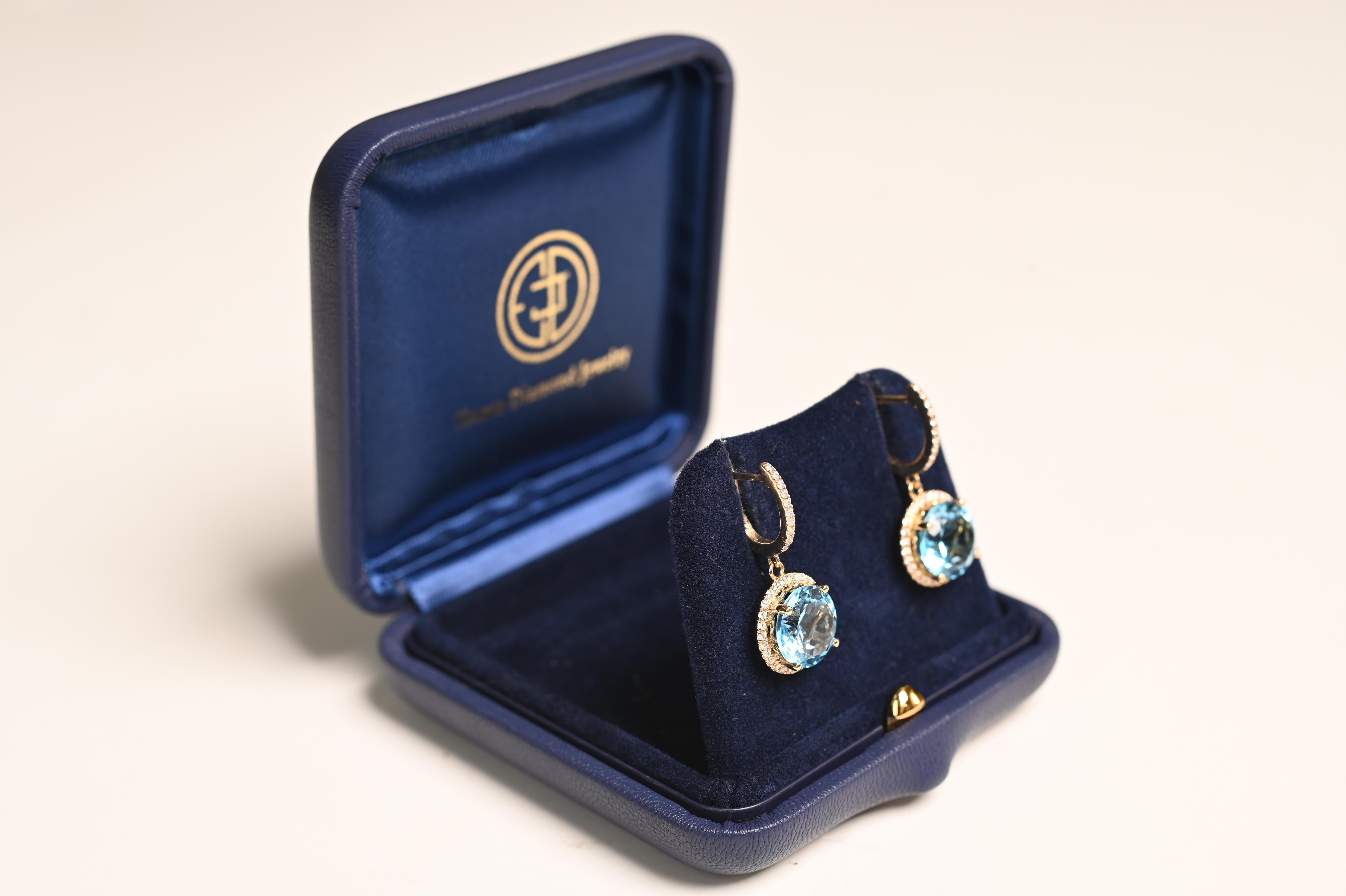 Ces boucles d'oreilles exquises témoignent d'un savoir-faire raffiné et d'une élégance intemporelle. Au centre, deux superbes topazes rondes d'environ 6,10 carats sont serties pour mettre en valeur leur couleur vibrante et leur éclat. Les pierres de