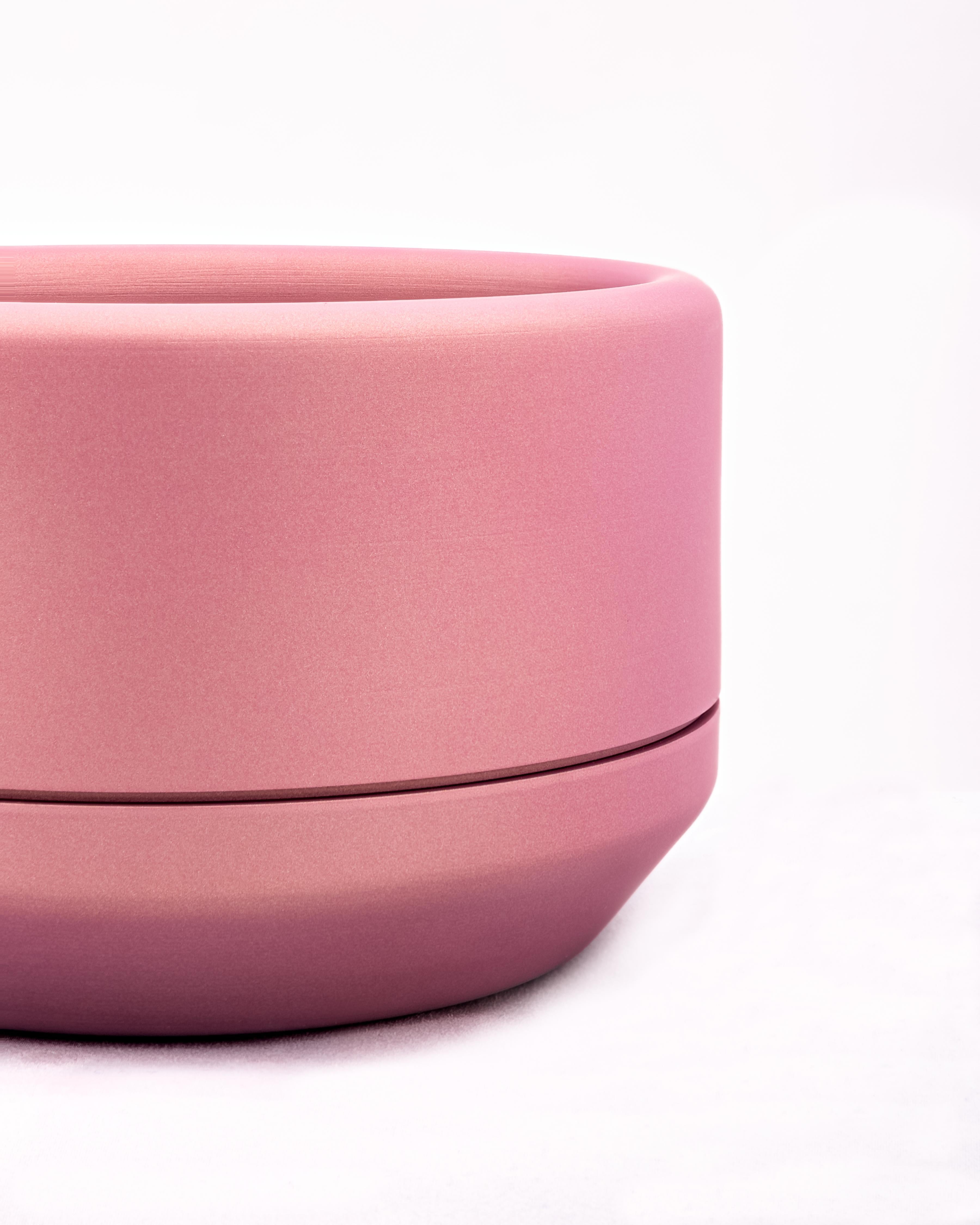 CNC milled and spun aluminum planter with pink ceramic coat finish. The main body of the planter is set on a loose spun aluminum drainage base. Interior dimensions are 5.5 inches diameter, and 2.75