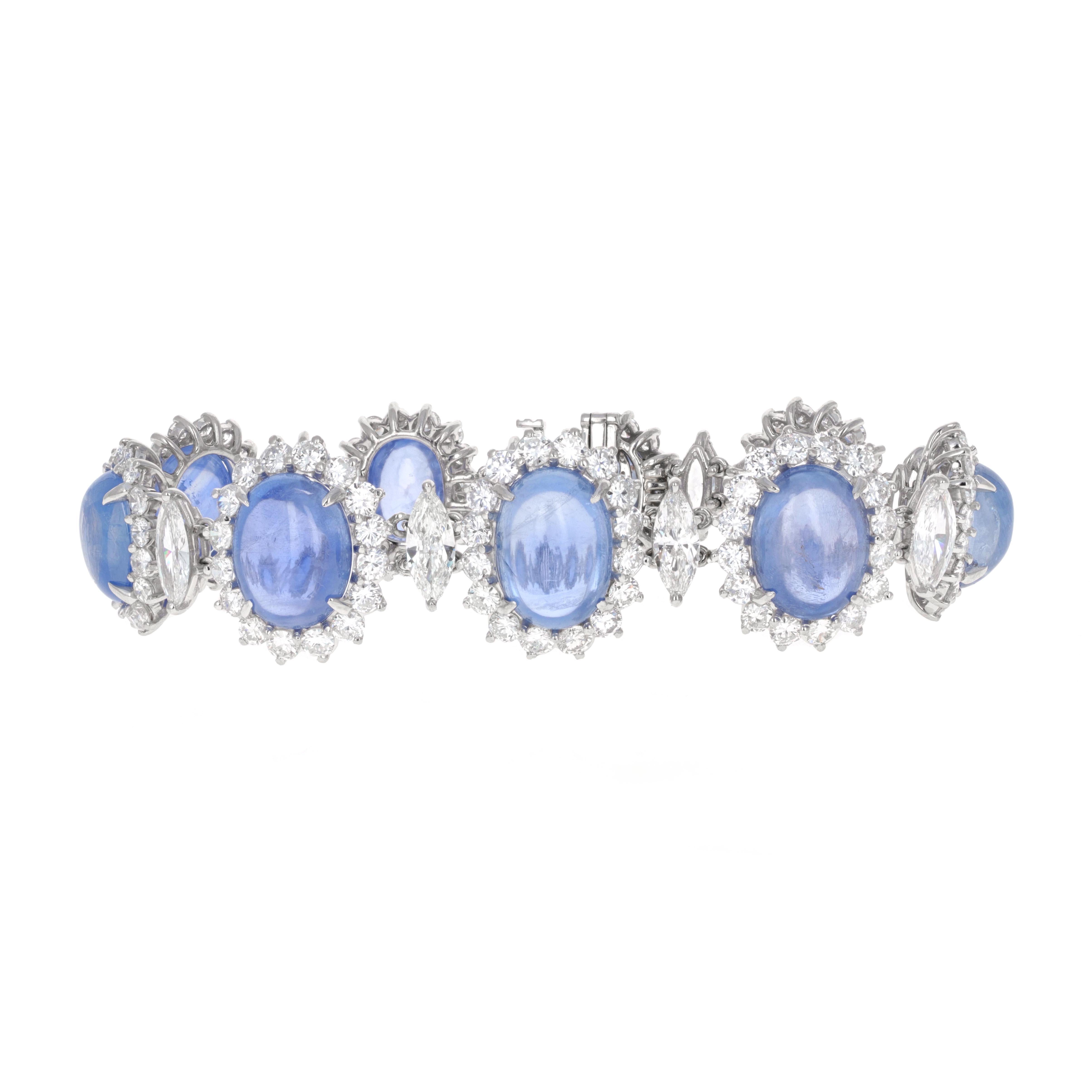 18 karat white gold blue sapphire cabochon and diamond bracelet. This is an estate piece in mint condition. There are 9 sapphires weighing an estimated 62.00 carats total weight. Each cabochon sapphire is surrounded by white, eye clean round