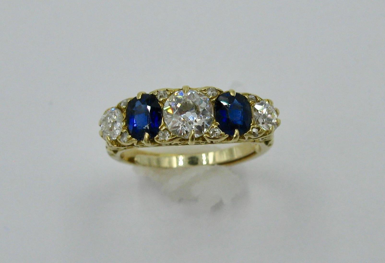 This is a stunning antique Victorian Wedding Engagement Ring with 1.08 Carat of Old European Cut Diamonds of superb white color and fire!  And 2 natural mined Blue Sapphires of incredible color and totaling .82 Carat.  The setting is a beautiful 18K