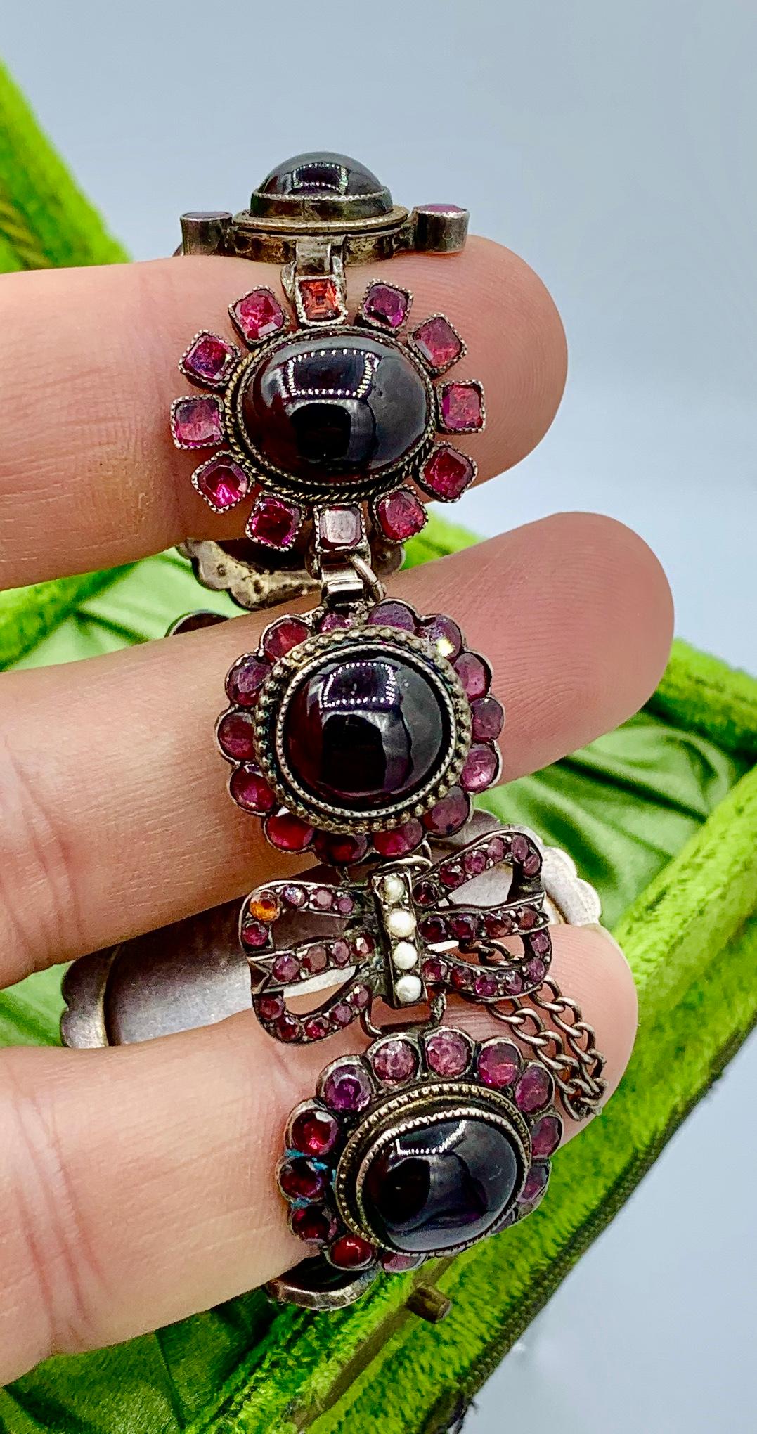 Bracelet et pendentif anciens en grenat, France, le bracelet est conçu comme un grand escarboucle centré et encadré de rubis, relié à des liens en forme d'escarboucle et d'arc en grenat, ainsi qu'un pendentif similaire serti d'émeraudes, de perles