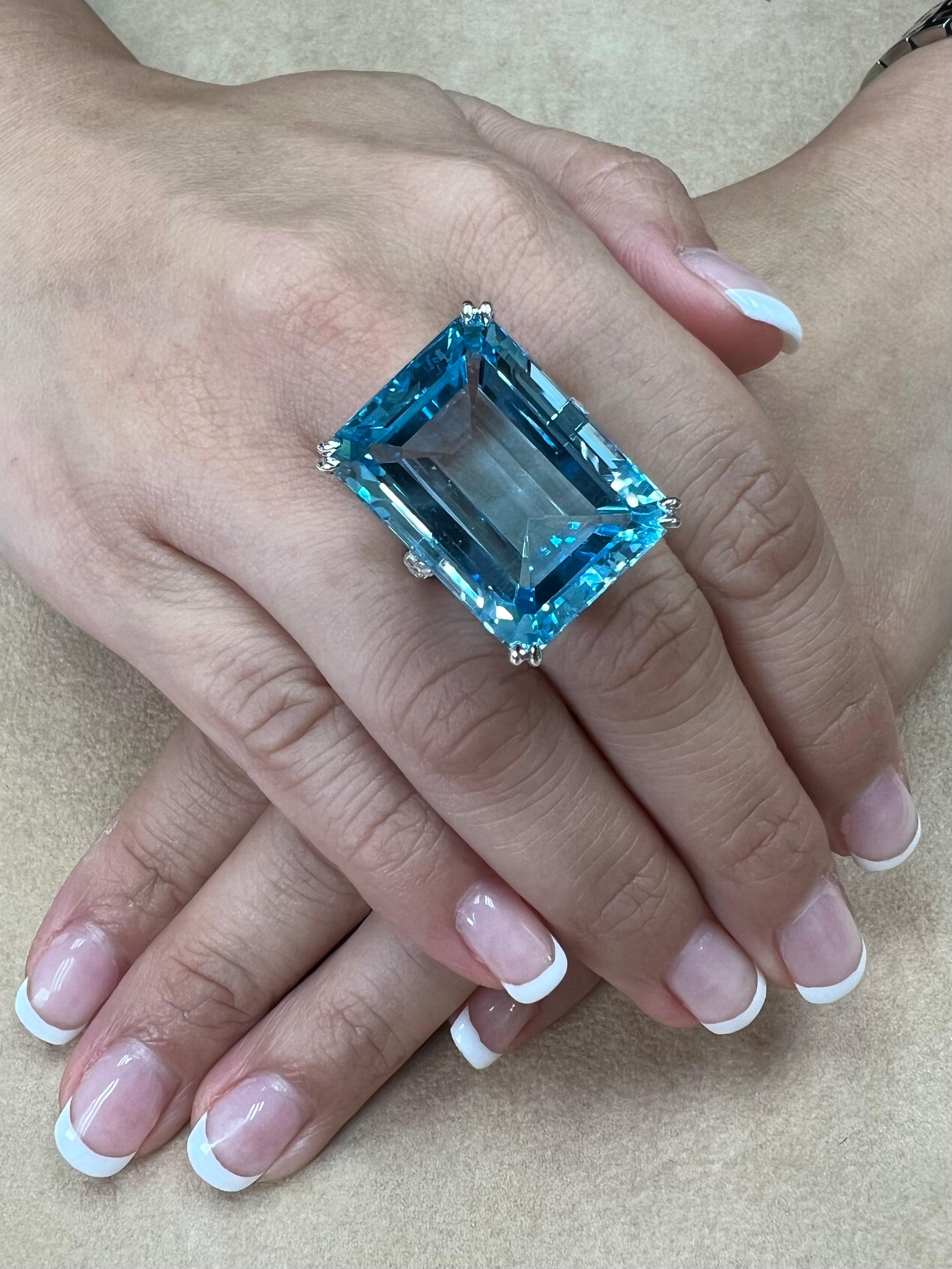 Please check out the HD video! Here is a super nice emerald step cut blue Topaz and diamond cocktail statement ring. It is set in 18k white gold. The 62.05 cts center Topaz is stunning in size, color and clarity. The color is an eye catching Swiss