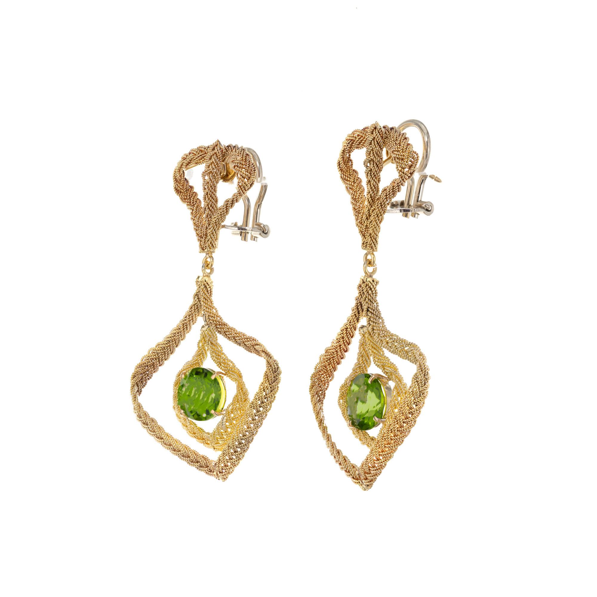 Peridot dangle earrings. Two round Peridot gemstones set in 18k yellow gold hand woven Italian clip post dangle, chandelier earrings. Even though these earrings are substantial, they are light and comfortable to wear. 

2 round green Peridot,