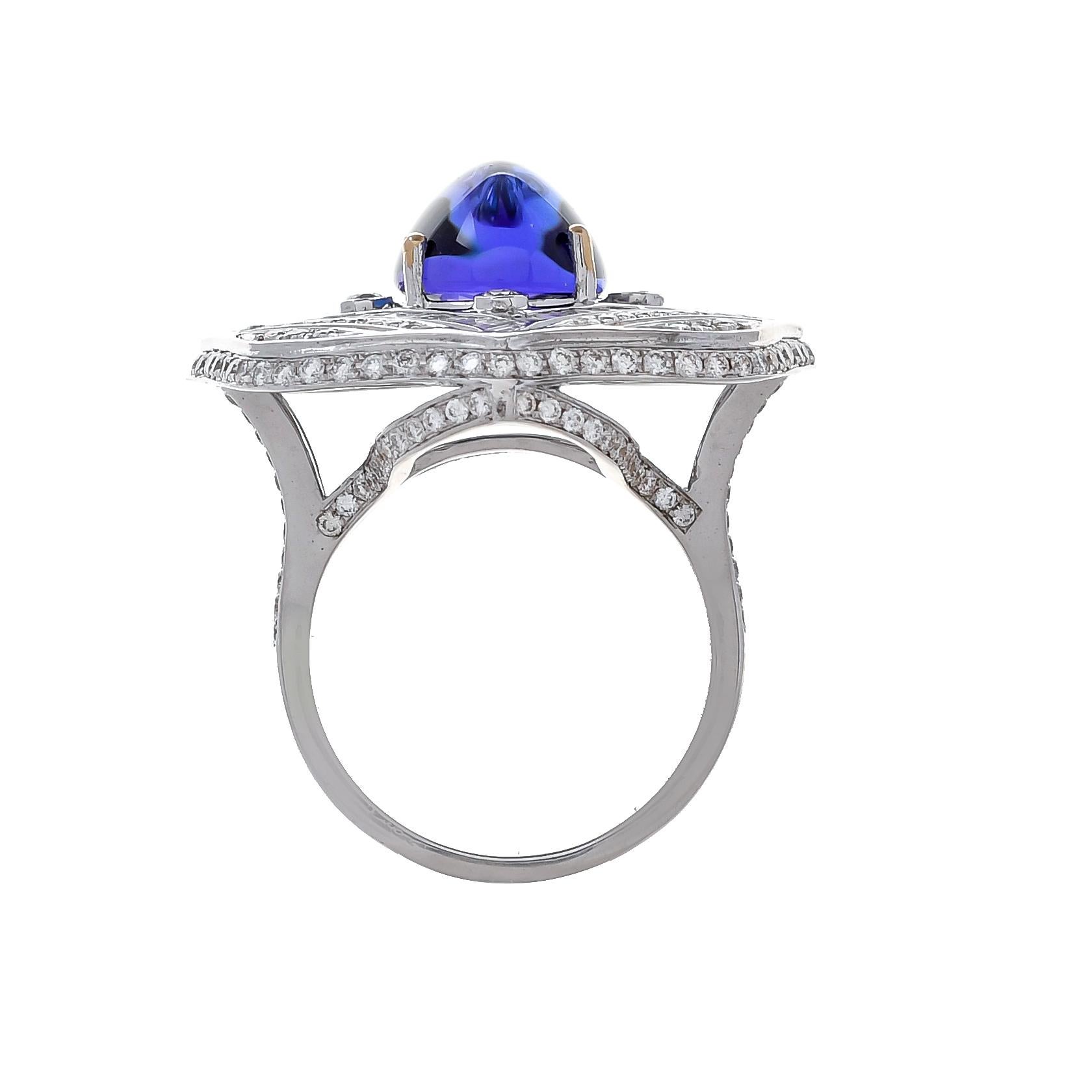 The cabochon tanzanite weighing approximately 6.20 carats set within a frame of baguette diamonds further accented with sparkling round diamonds with a total diamond weight of 2.30 carats, completed by bifurcated shoulders studded with diamonds.