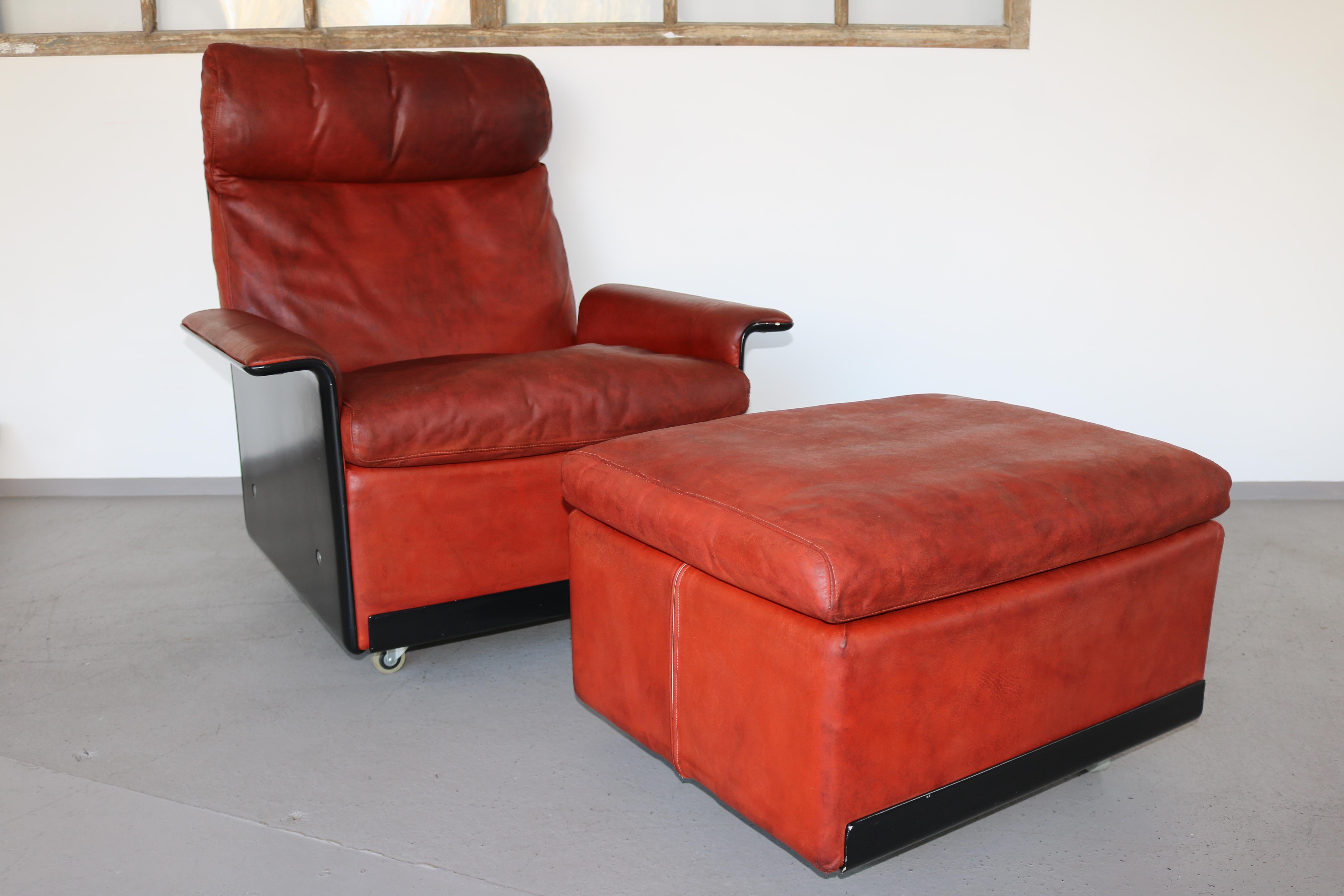 The extremely comfortable 620 high back chair by Dieter Rams for Vitsoe with ottoman.
The shell is in black and the leather in rusty red. The armchair and the stool are on wheels.
The leather has good patina, but no holes or cracks. It was