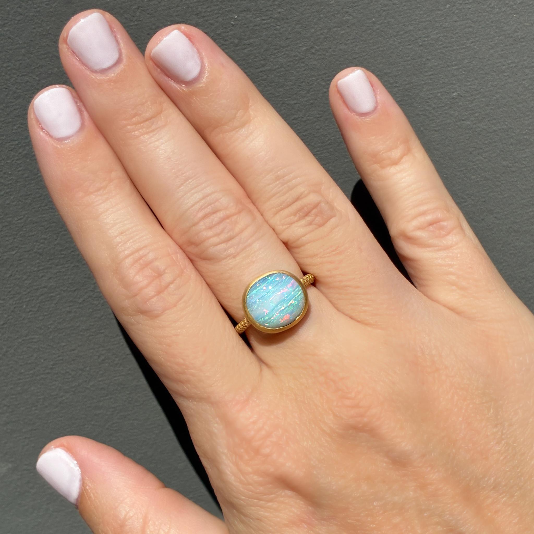 Créée par Shinobu Marotta de Talkative Atelier au Japon, cette fascinante bague en opale de roche australienne capture la magie de la couleur et de l'artisanat en parfaite harmonie. La pièce maîtresse est une opale massive de 6,21 carats, qui