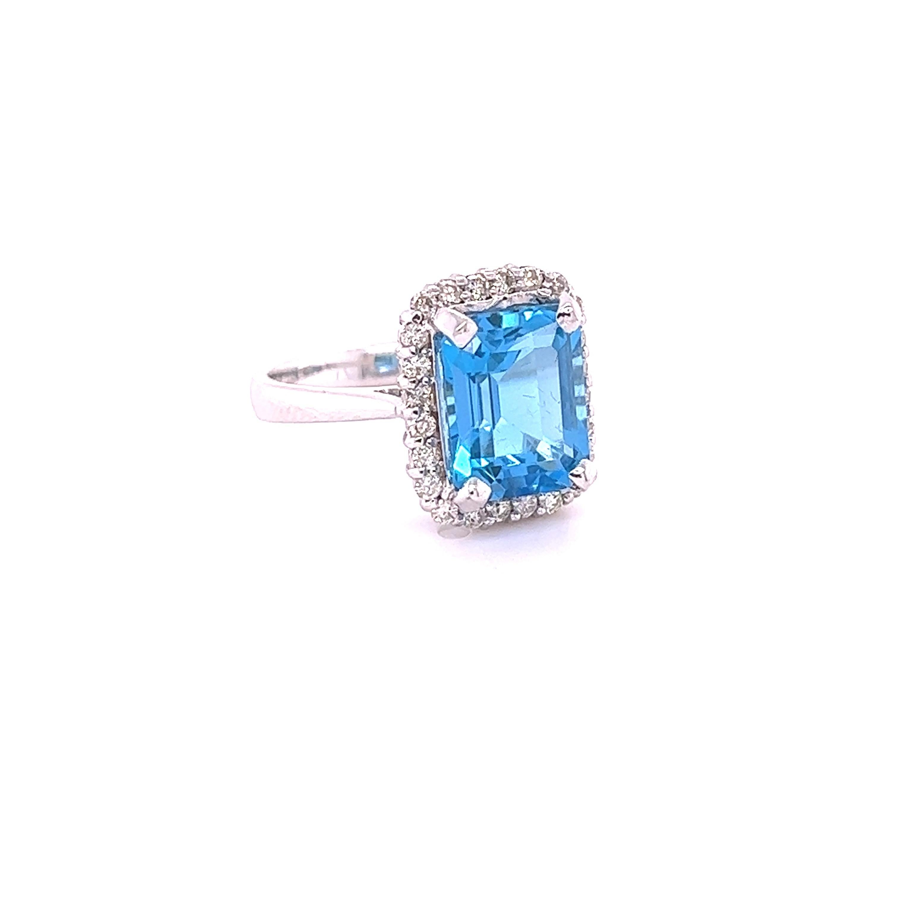 This ring has a Emerald Cut Blue Topaz that weighs 5.78 carats and measures at 11 mm x 9 mm. 

It is surrounded by a simple halo of 24 Round Cut Diamonds that weigh 0.44 Carats. 

It is crafted in 14 Karat White Gold and weighs approximately 5.7