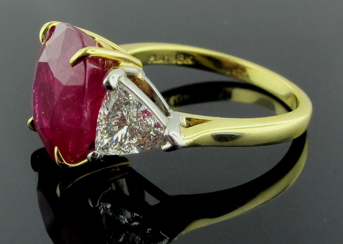 Set in 18 karat yellow gold is a 6.22 carat oval cut Ruby, AGL cert #CS 64604, with 2 side trilliant cut diamonds with a total diamond weight of 1.26 carats.